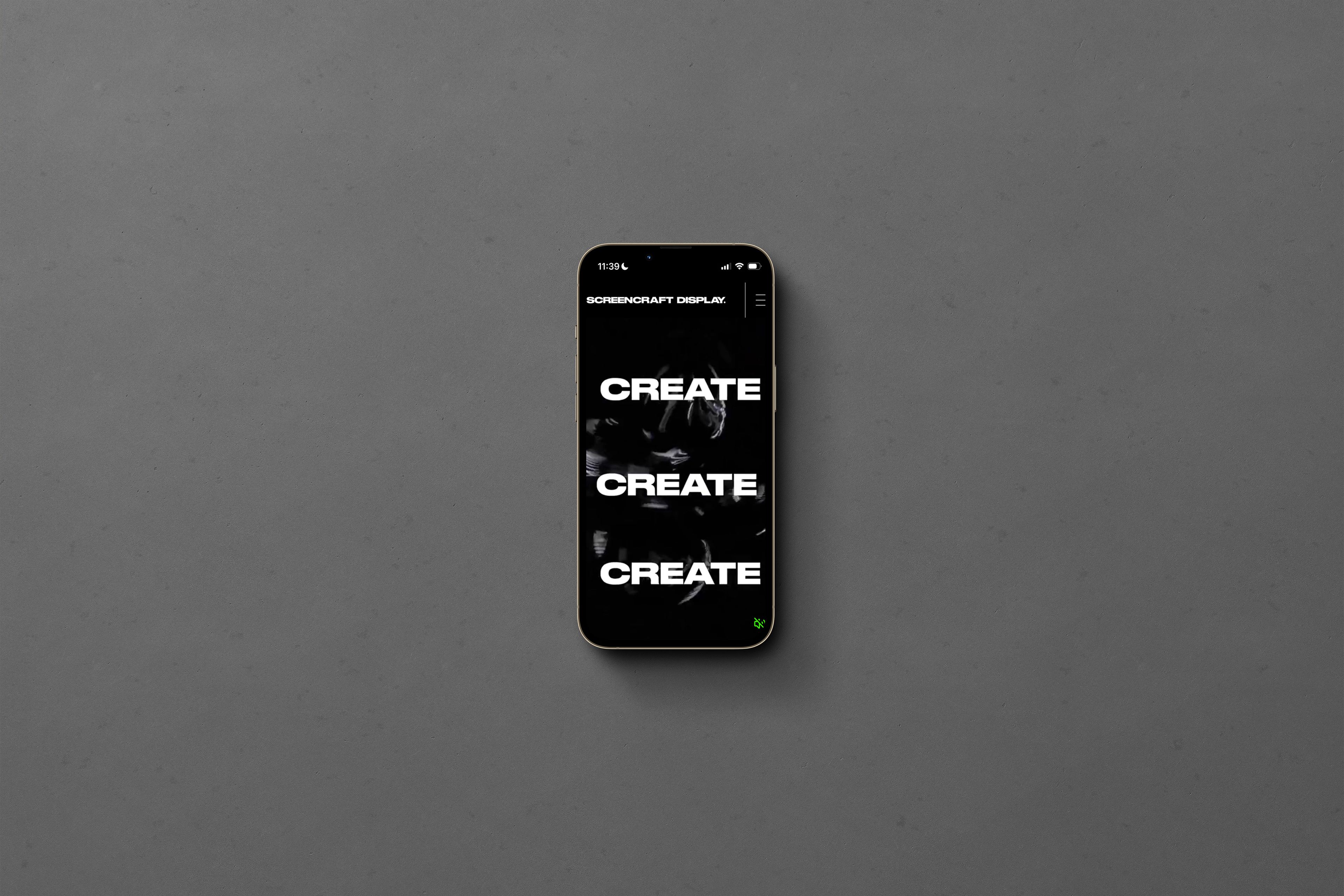 Smartphone on a grey background, its screen repeating the word CREATE in bold white type