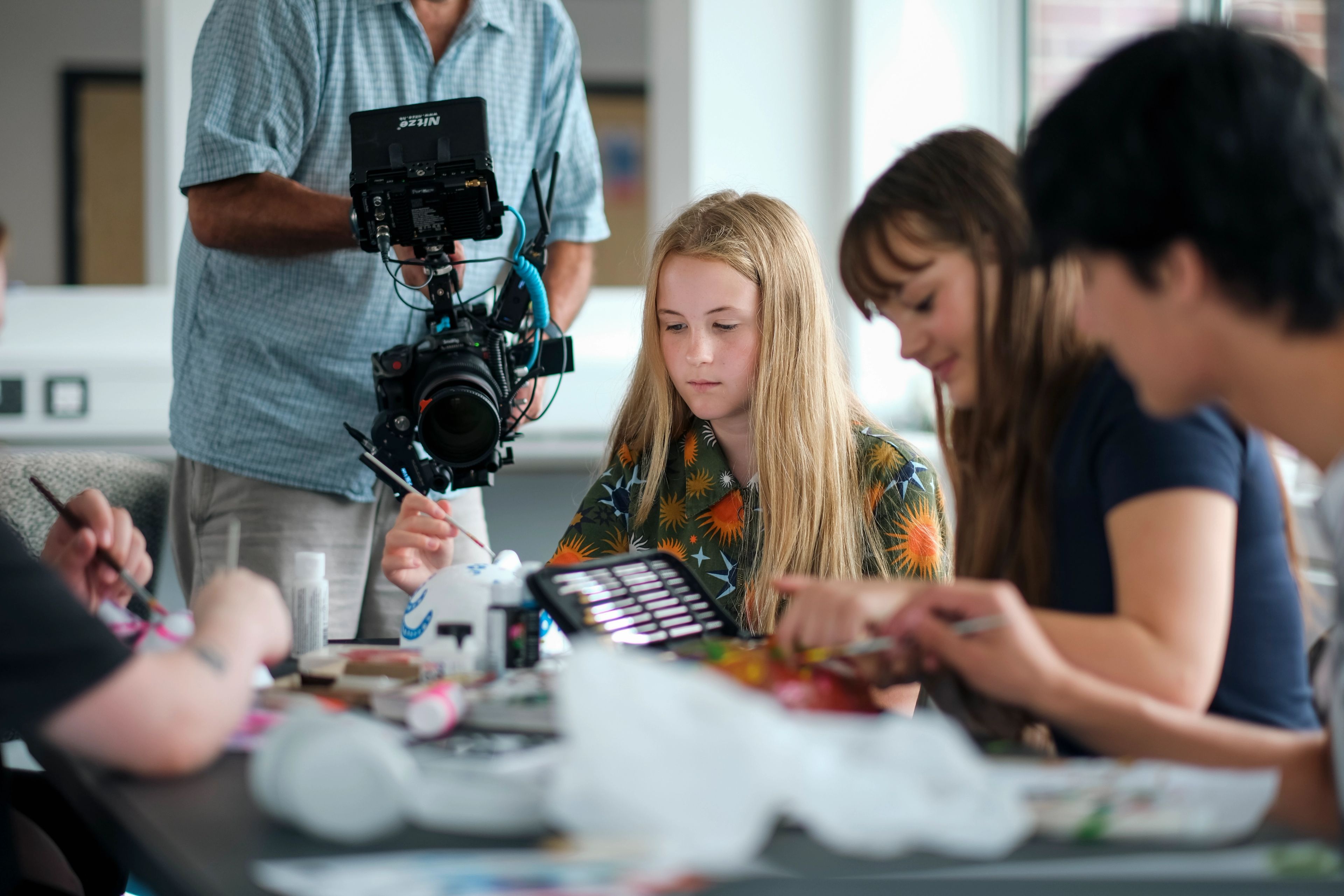 Filming a young artist painting at an art class table for the BeU Swindon campaign video