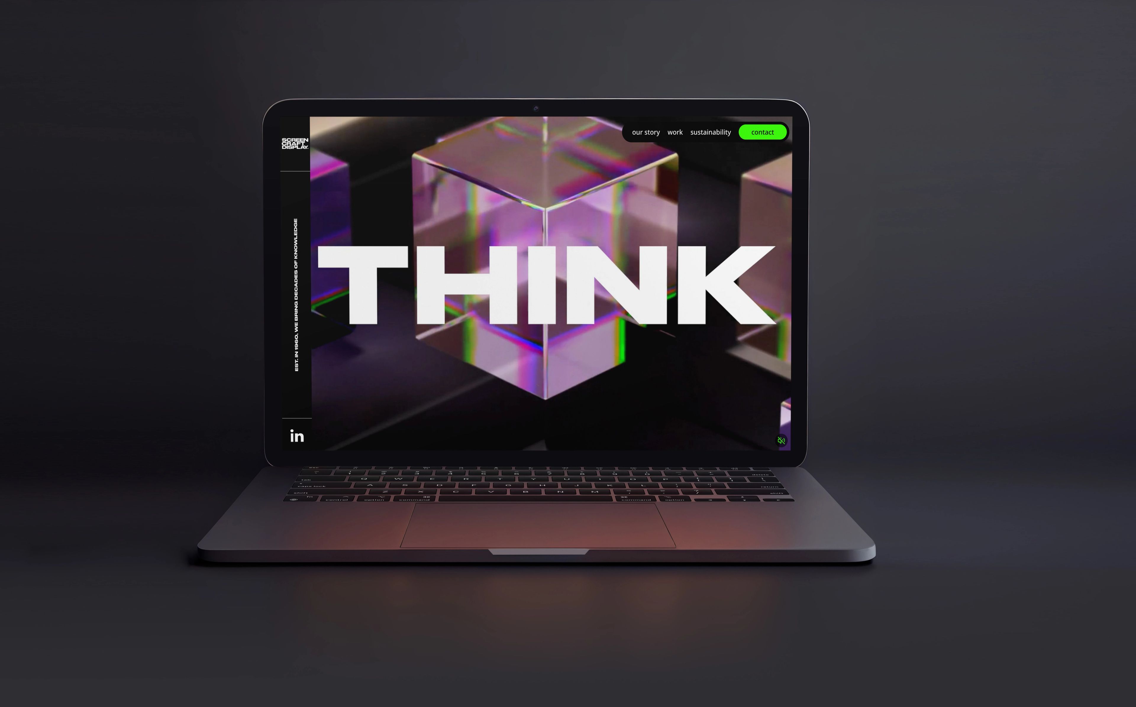 Laptop showing a dark website homepage with a bold THINK headline over an iridescent glass cube