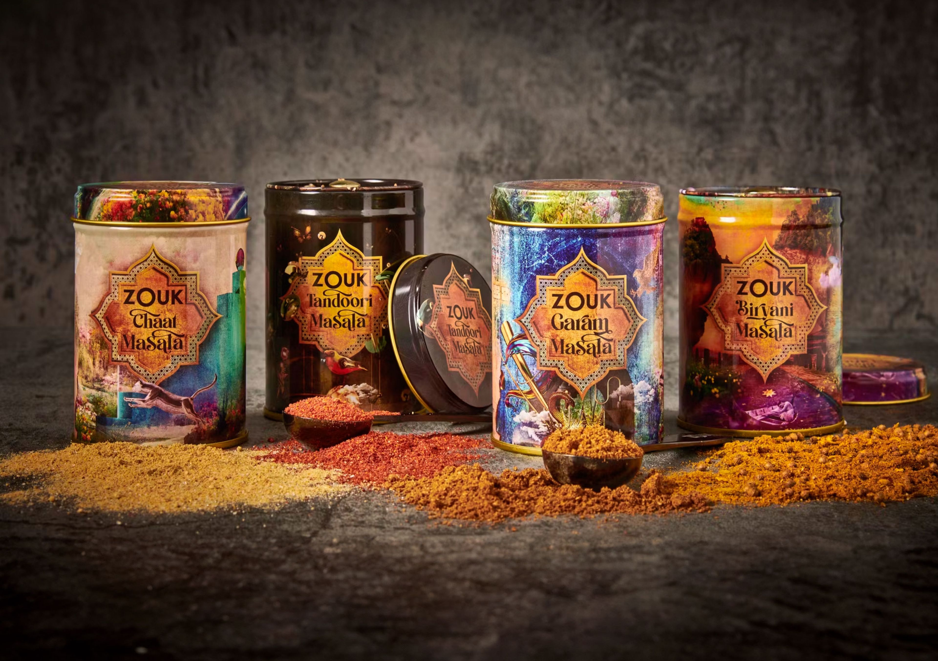 Zouk masala spice tins with illustrated packaging beside piles of ground spices