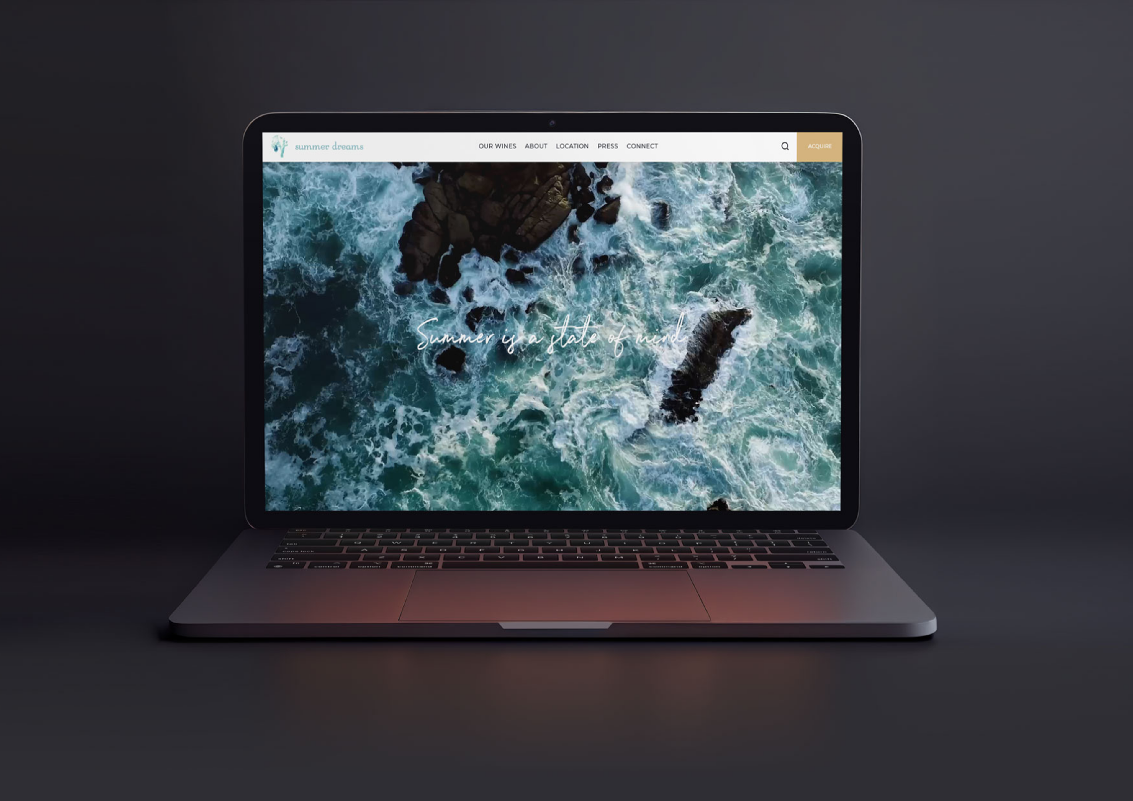 Laptop displaying a website hero with aerial photography of waves breaking over dark rocks