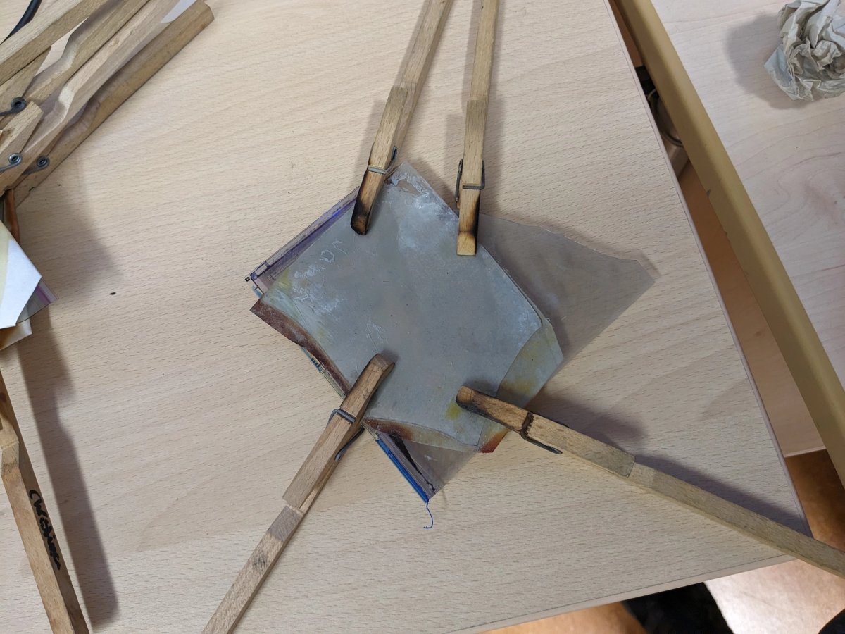 A cursed sandwich of Glass, with white filter paper in between and some lab clamps holding it together... 