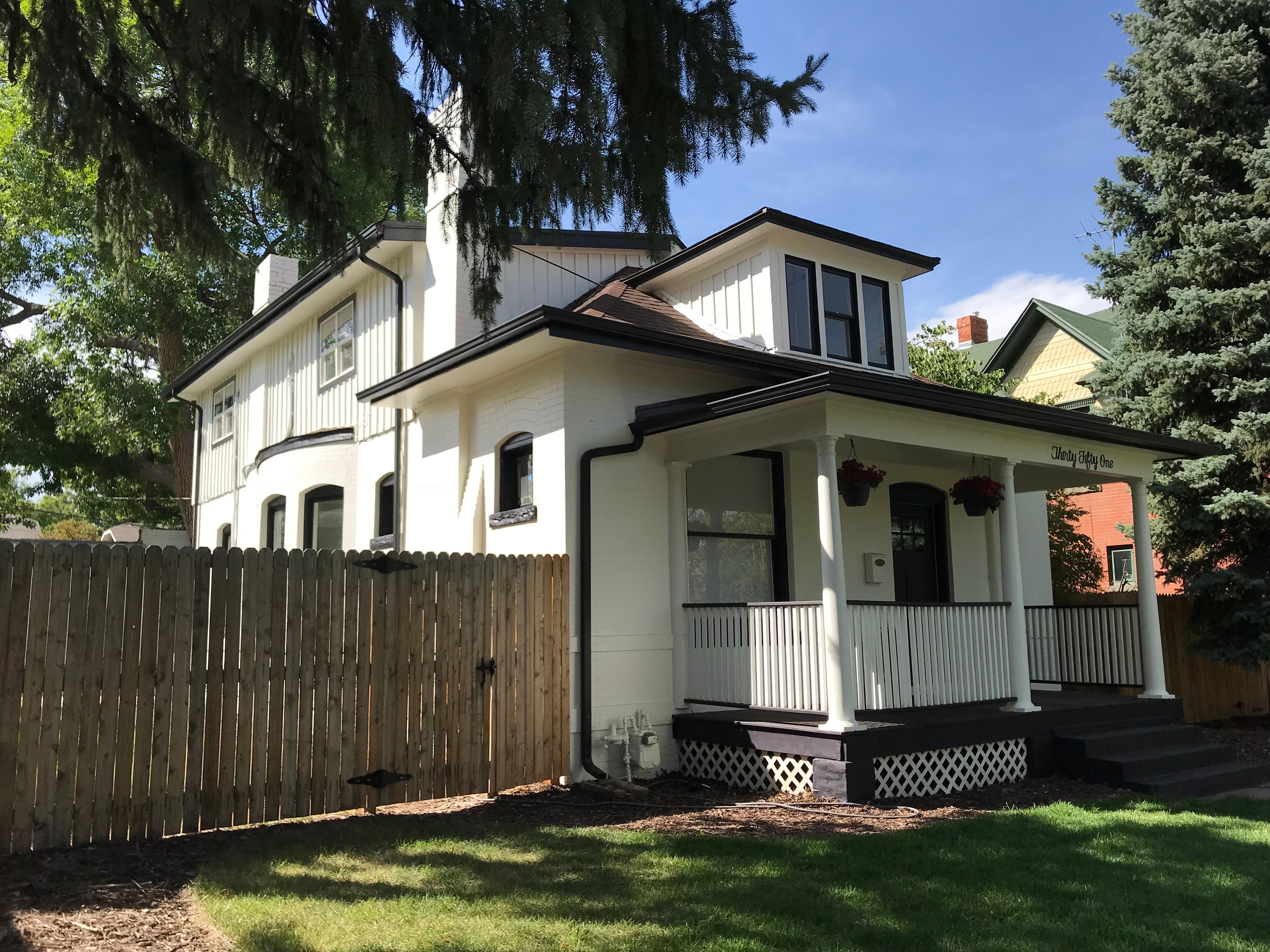 Beautiful sunny brick home surrounded by green trees that Storey owns