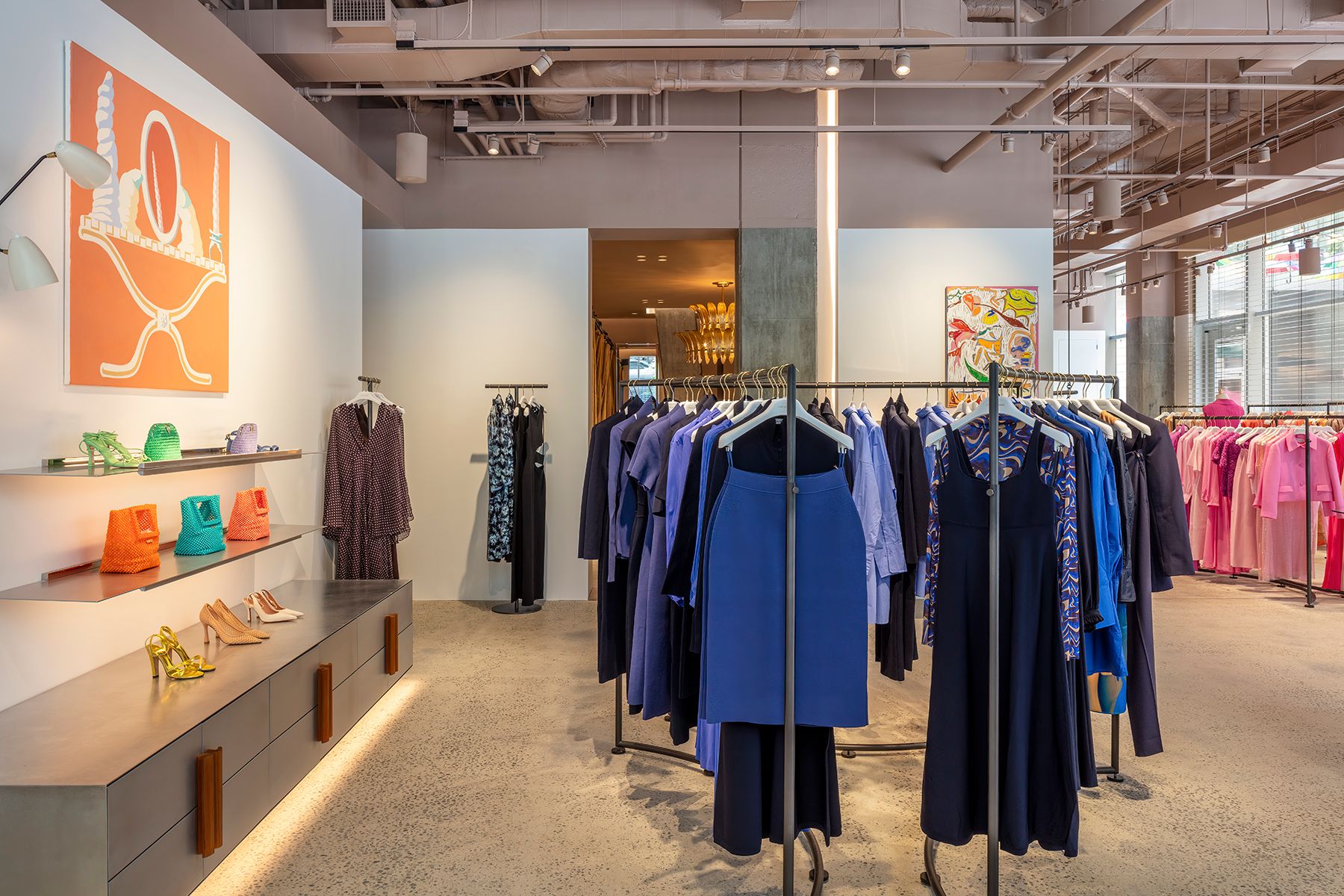 Interior view of the boutique with racks of blue women's clothing and shelves with various shoes and bags