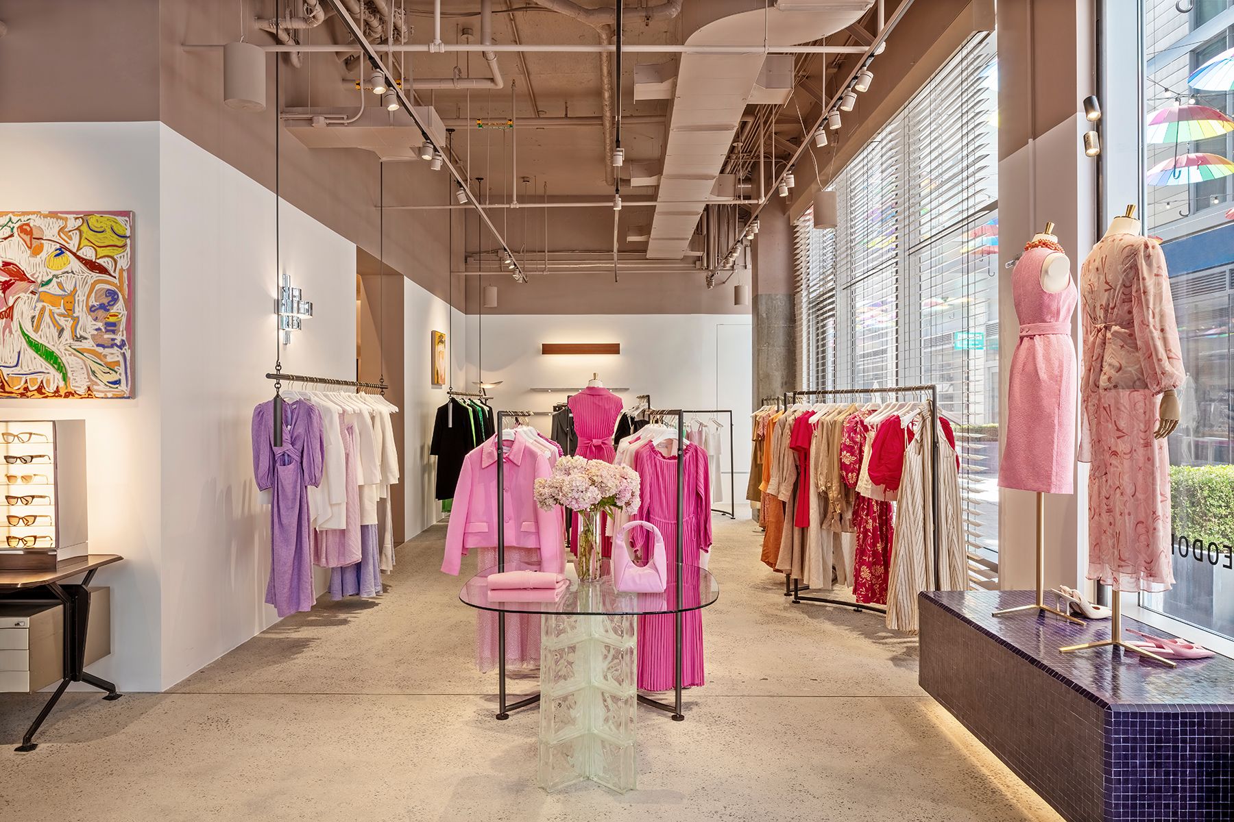 Interior view of the boutique with racks of pink, white, red and purple women's clothing