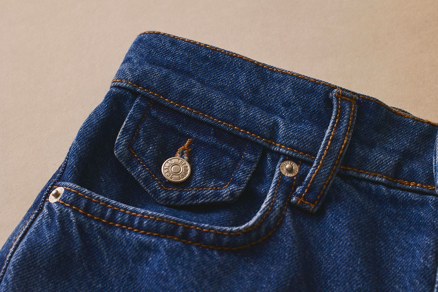 Scanlan Theodore denim jeans in a deep indigo hue and detail of pocket, button and belt loop.