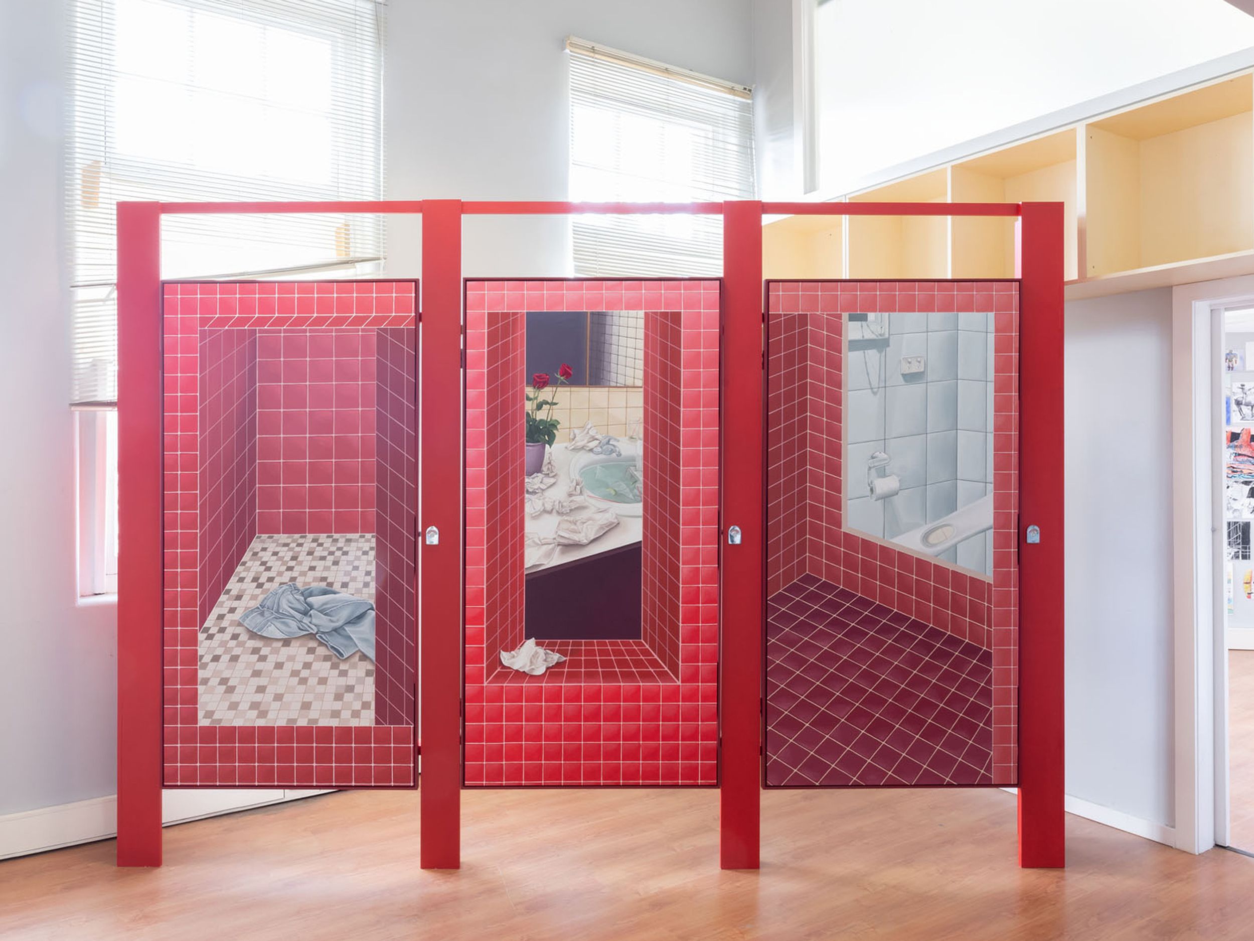 Artwork of three red tiled stalls with illustrations of bathrooms