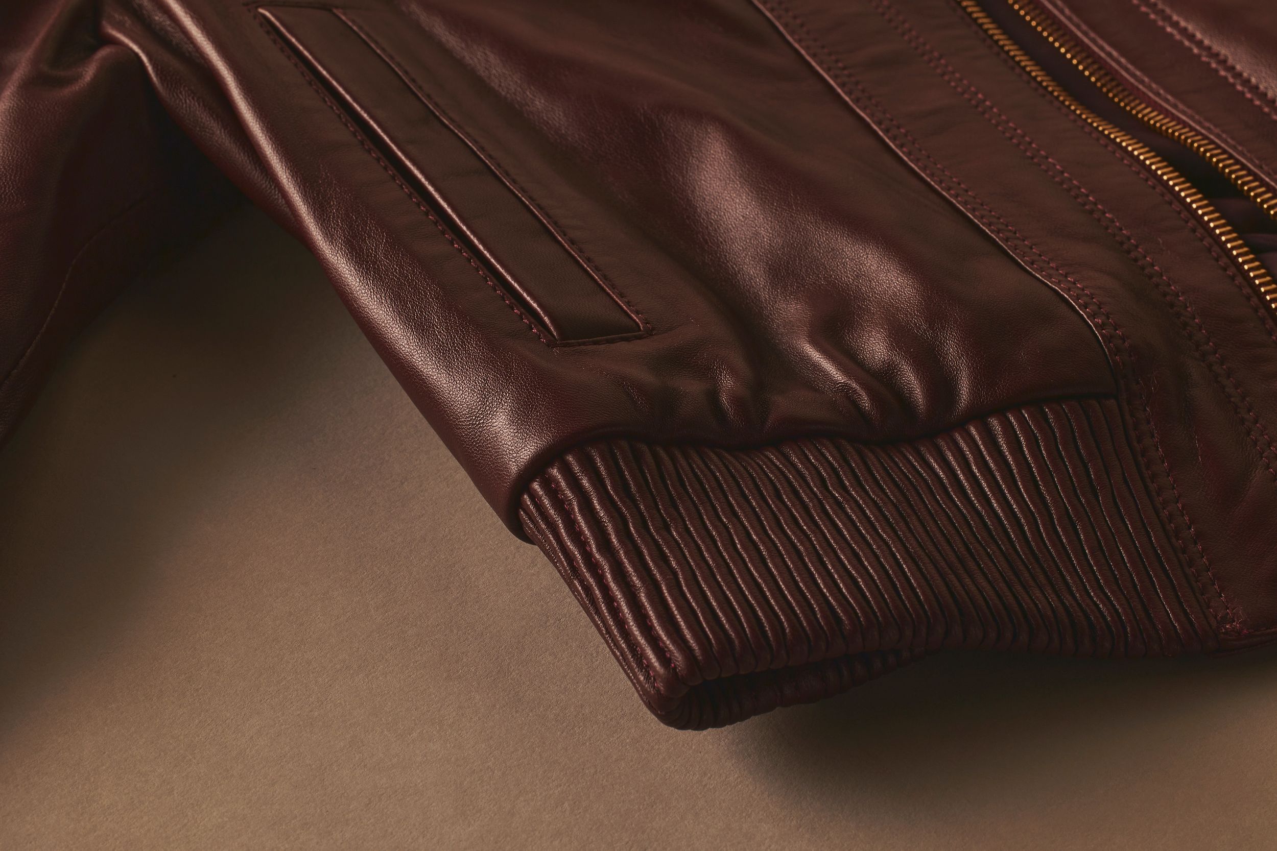 Scanlan Theodore leather bomber jacket with close detailed view of pocket, zipper and elasticated trim.
