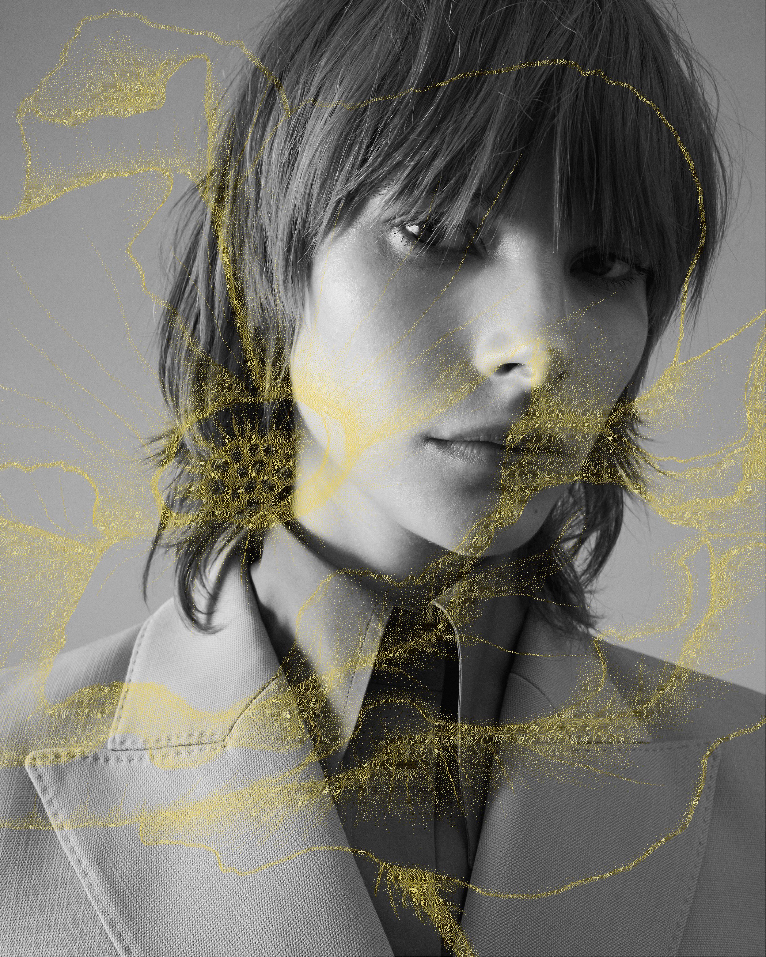 Black and white image of close up of model's face with yellow poppy illustration overlaid on top