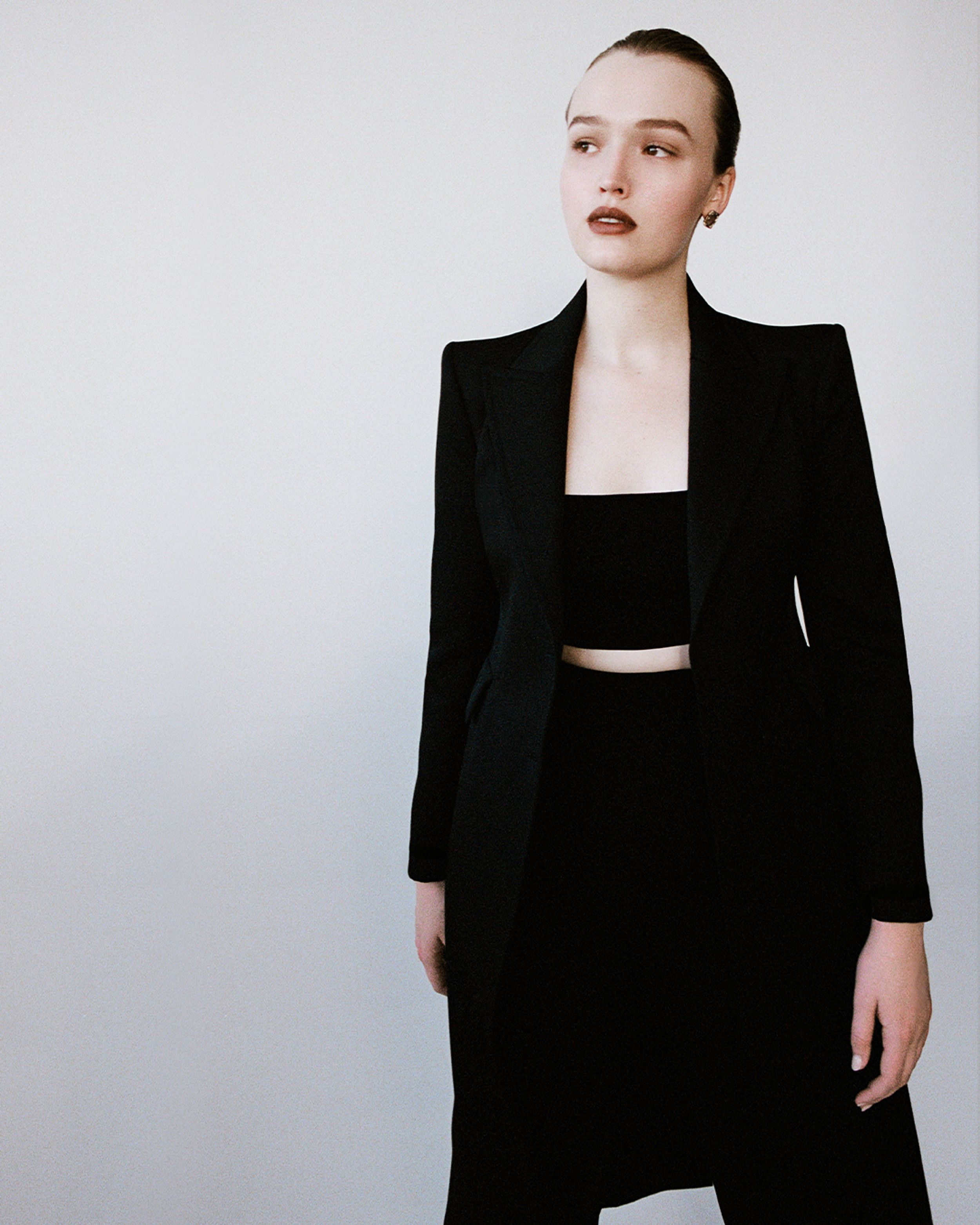 Maddison Brown standing in black jacket and black trousers with hair in a bun