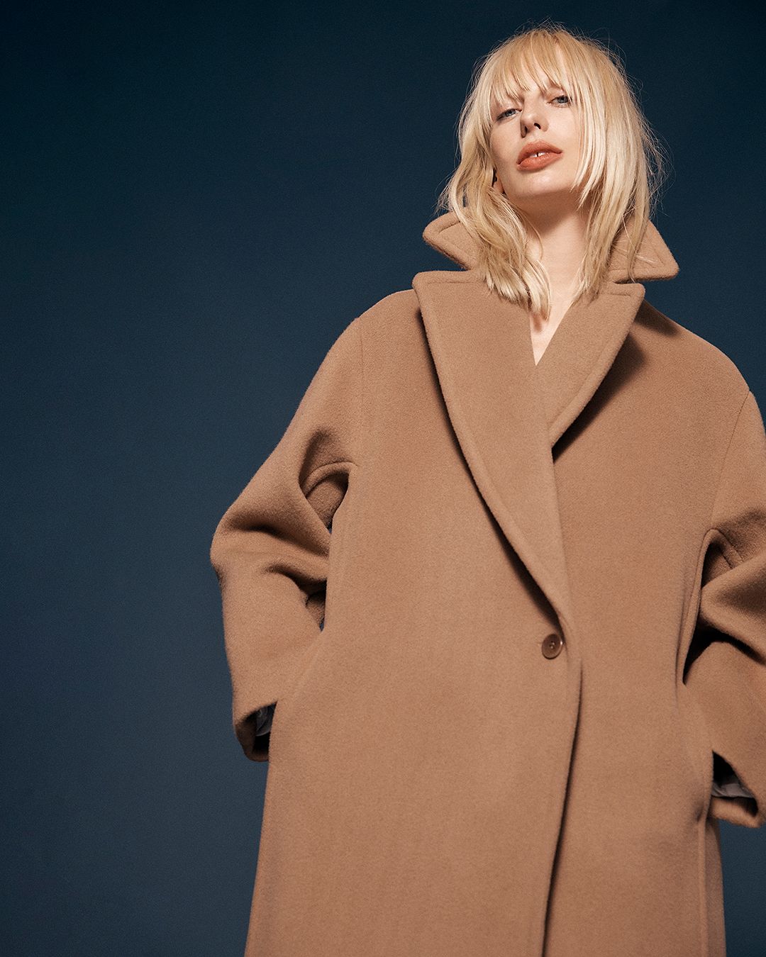 Blonde model wearing a beige single-button coat