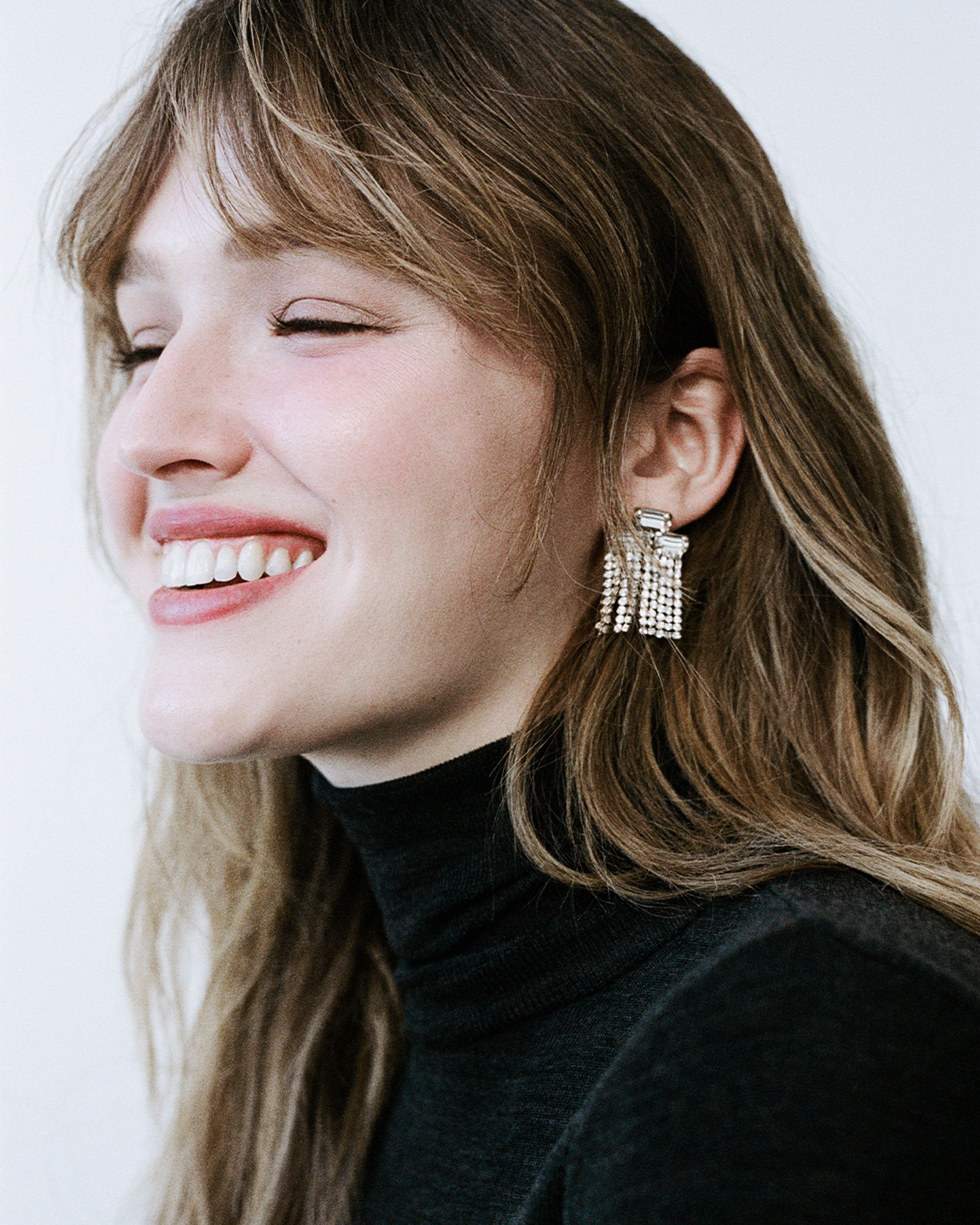 Close up of Maddison Brown smiling with diamante drop earrings
