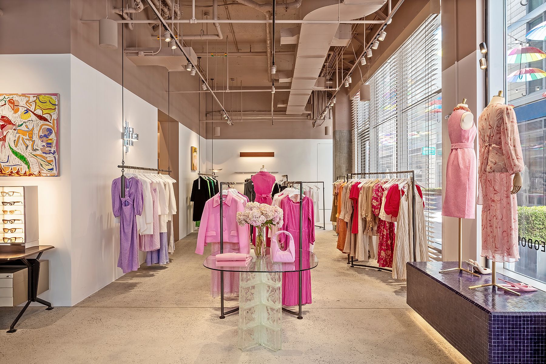Interior view of the boutique with racks of pink, white, red and purple women's clothing