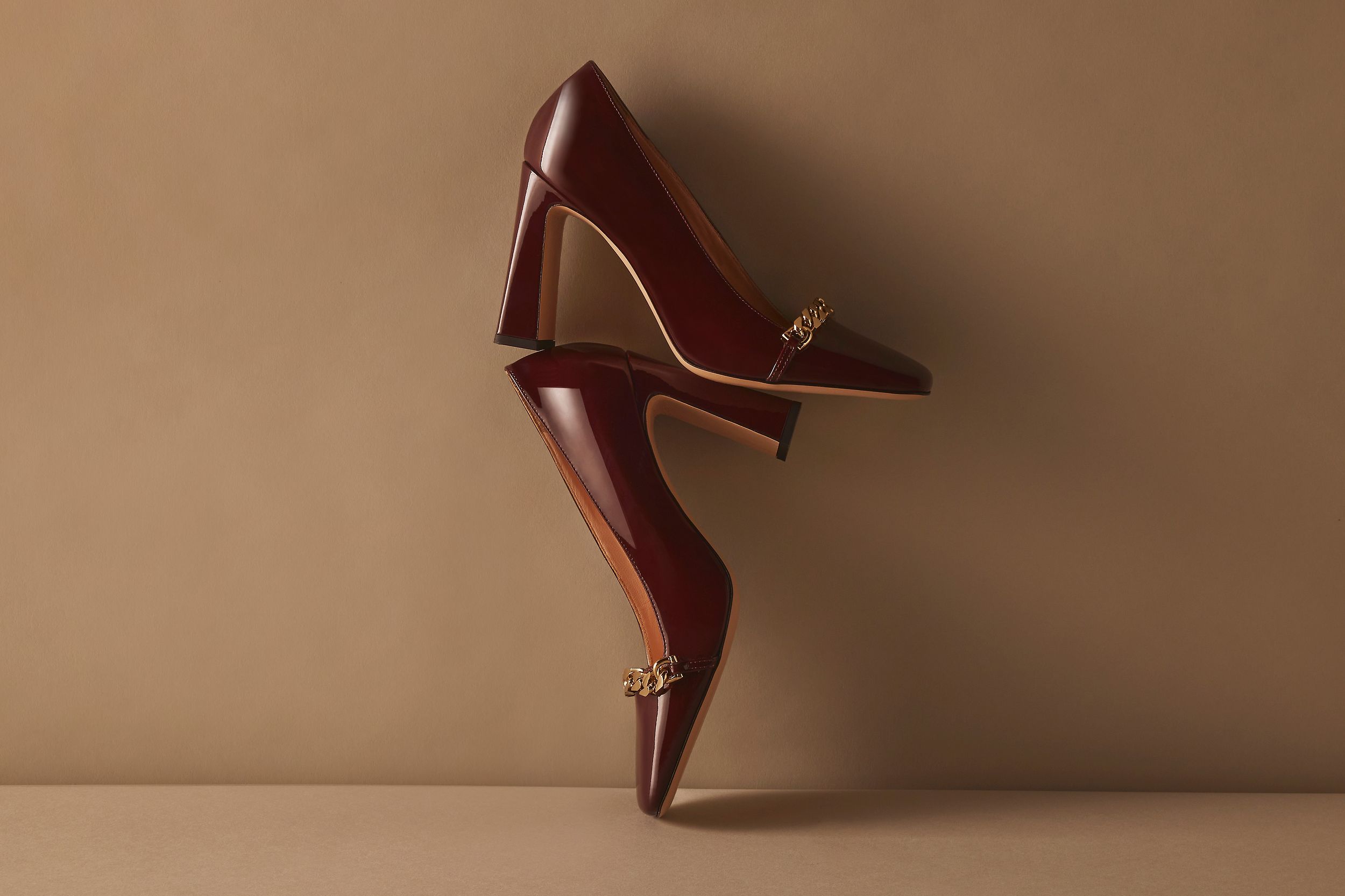 Scanlan Theodore square toe pump balancing on top of each other with chain detail.