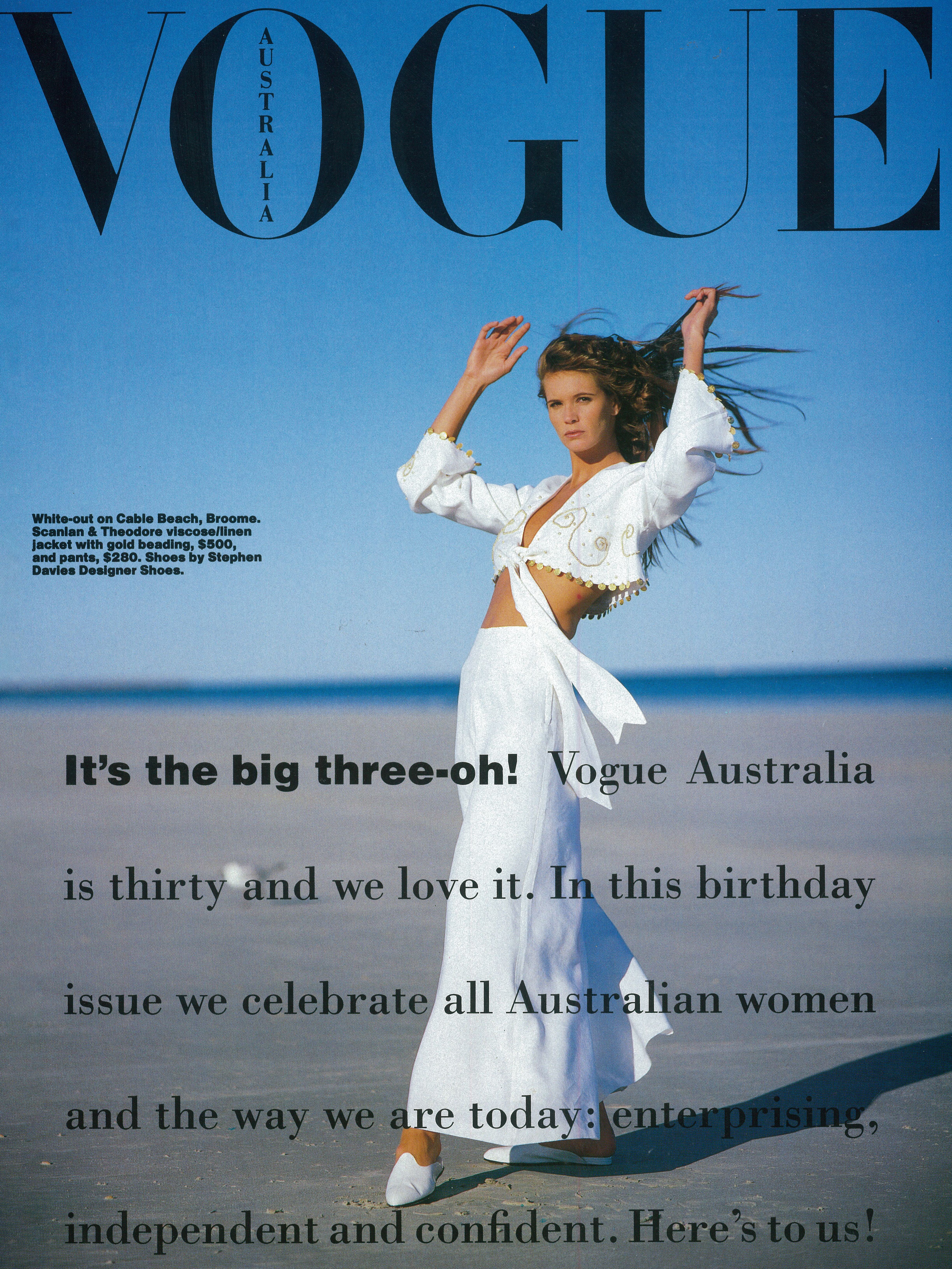 Vogue Australia magazine cover with Elle Macpherson on the beach wearing a white long-sleeve cropped top and white maxi skirt