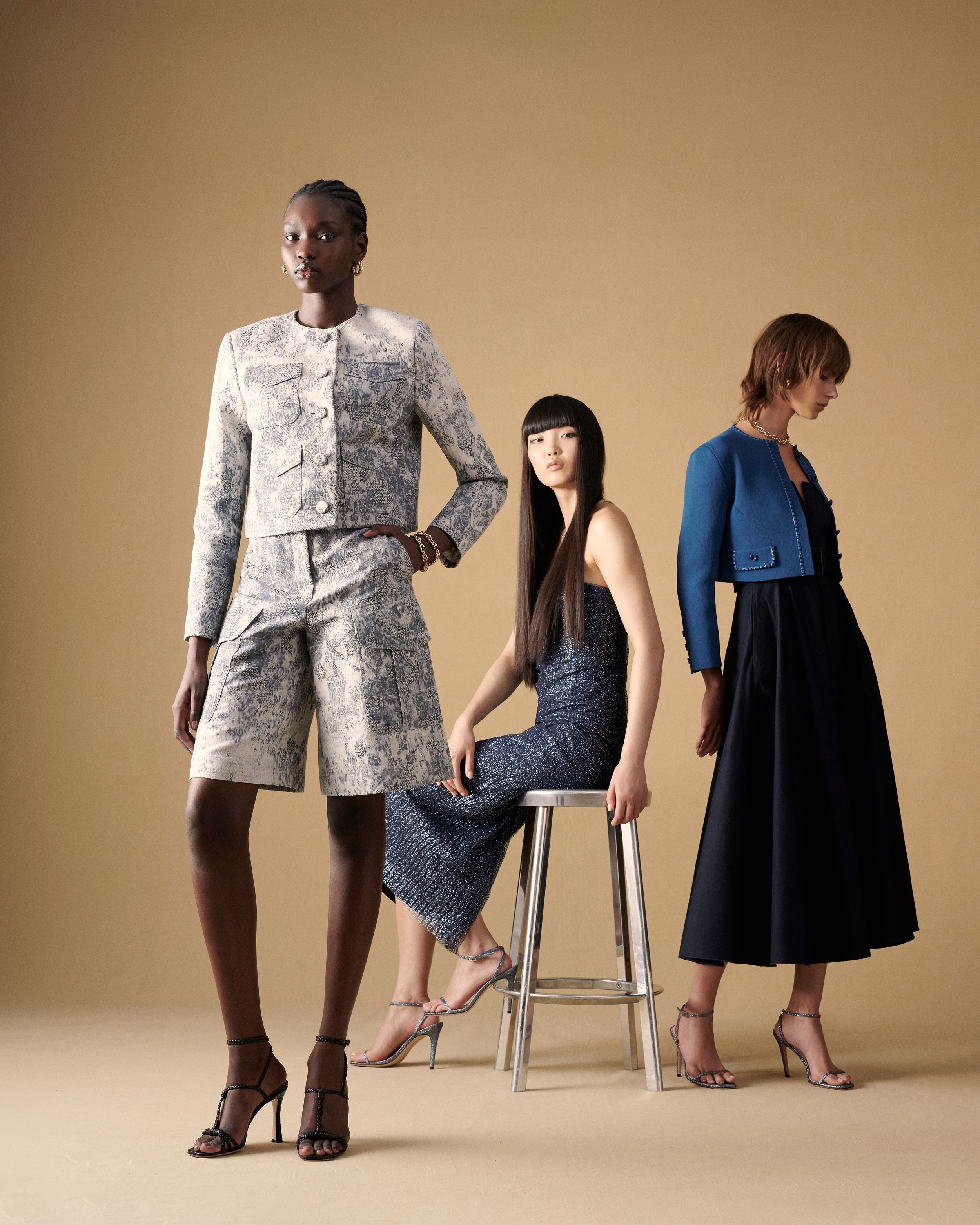 Three models posing wearing a blue and white matching set, blue evening gown, and blue Crepe Knit jacket with dress