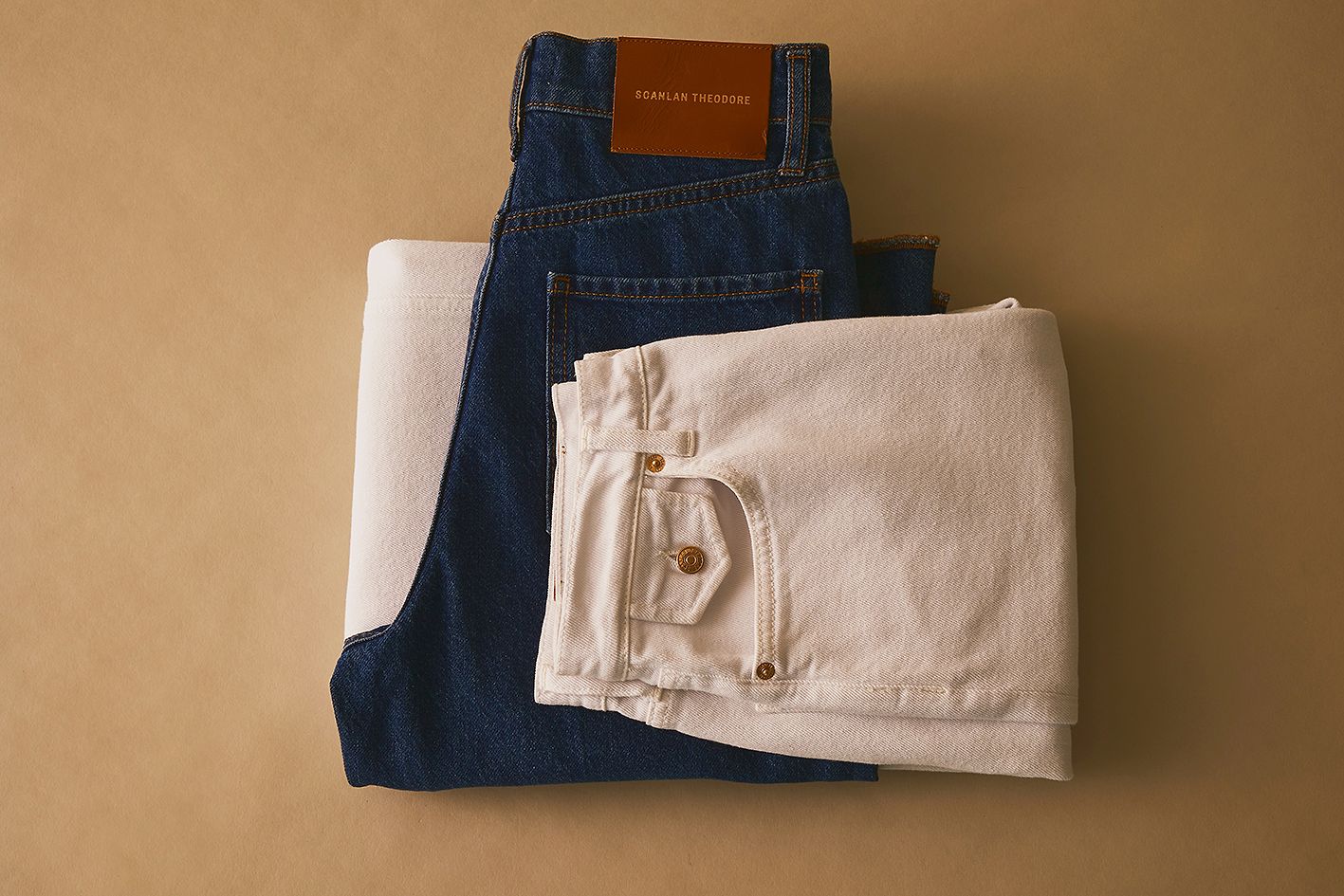 Scanlan Theodore denim jeans folded and stacked on top of each other in range of colours.