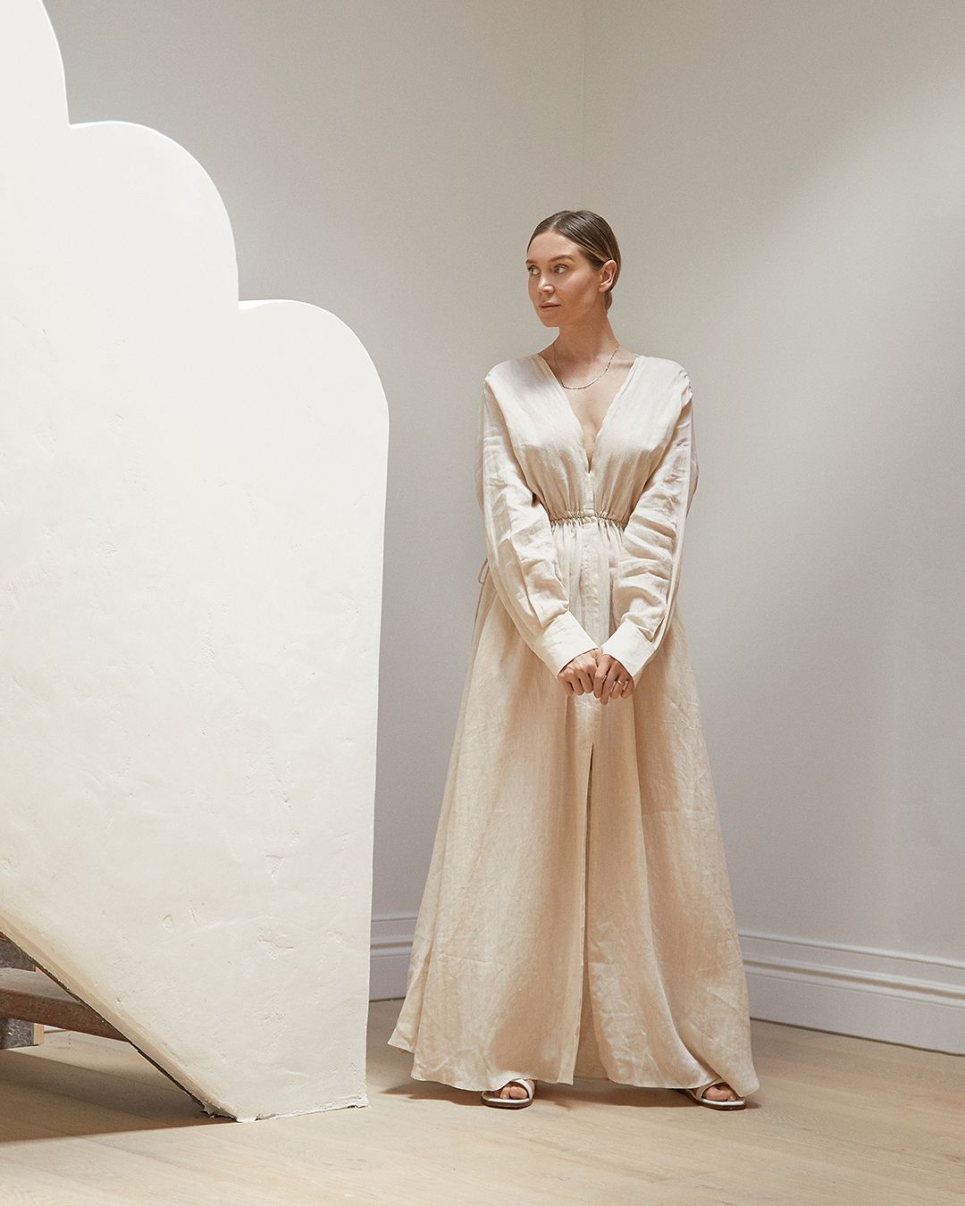 Women with hair in a sleek bun wearing a long maxi dress with v-neckline