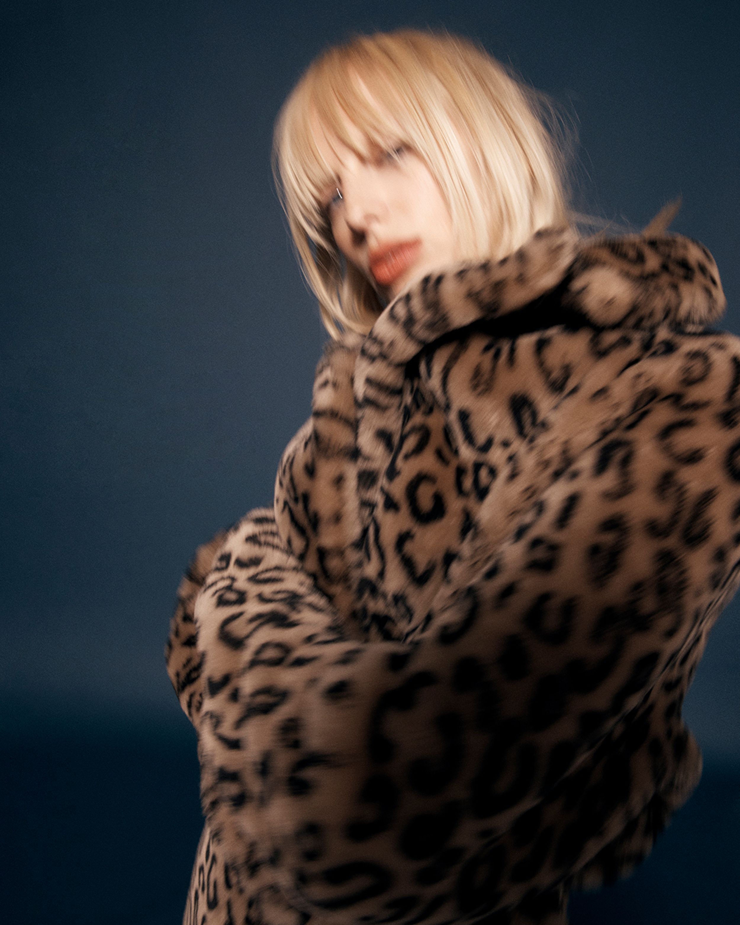 Blonde posing with arms crossed in a leopard-print coat