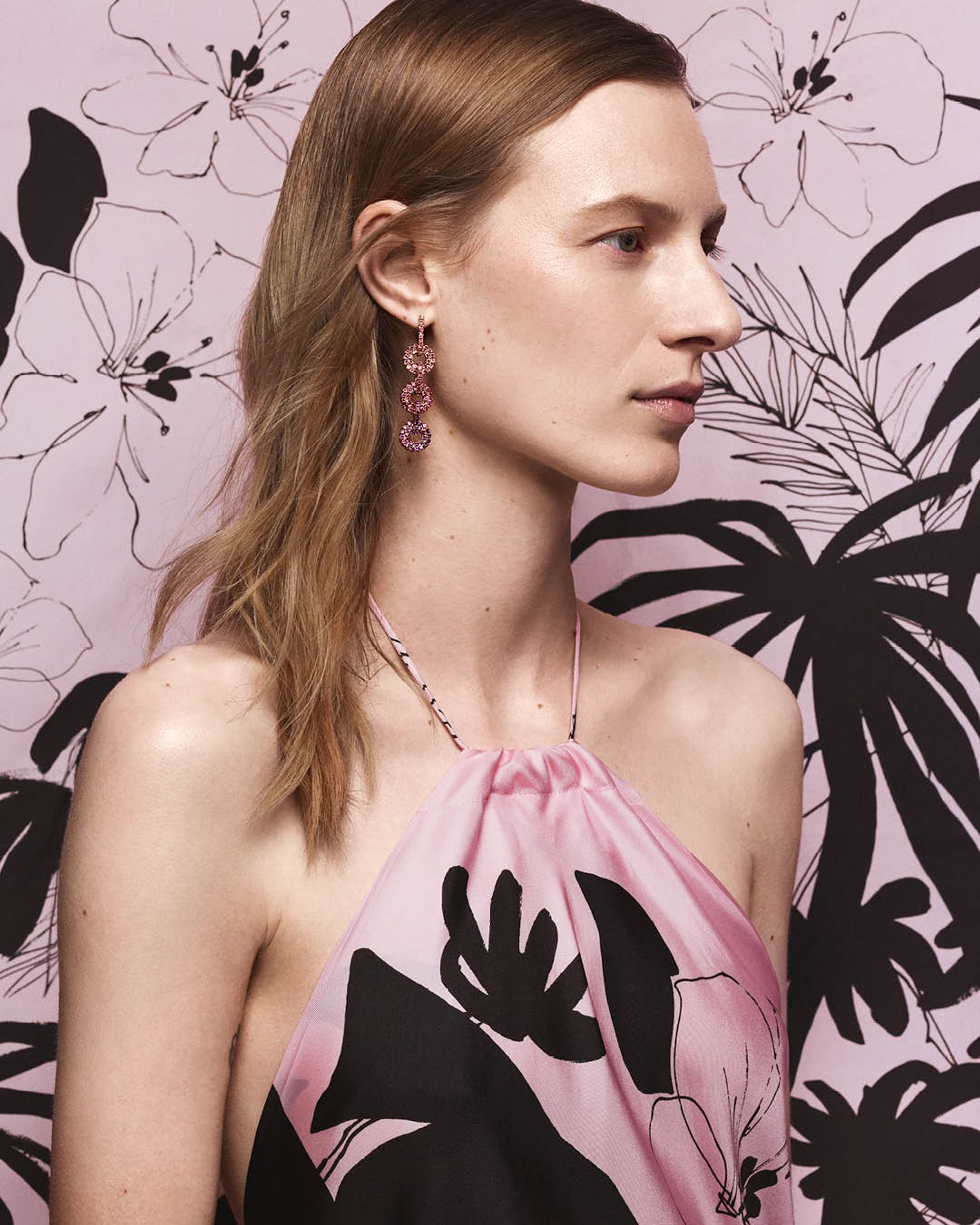 Julia Nobis facing the side wearing a pink silk halterneck dress 