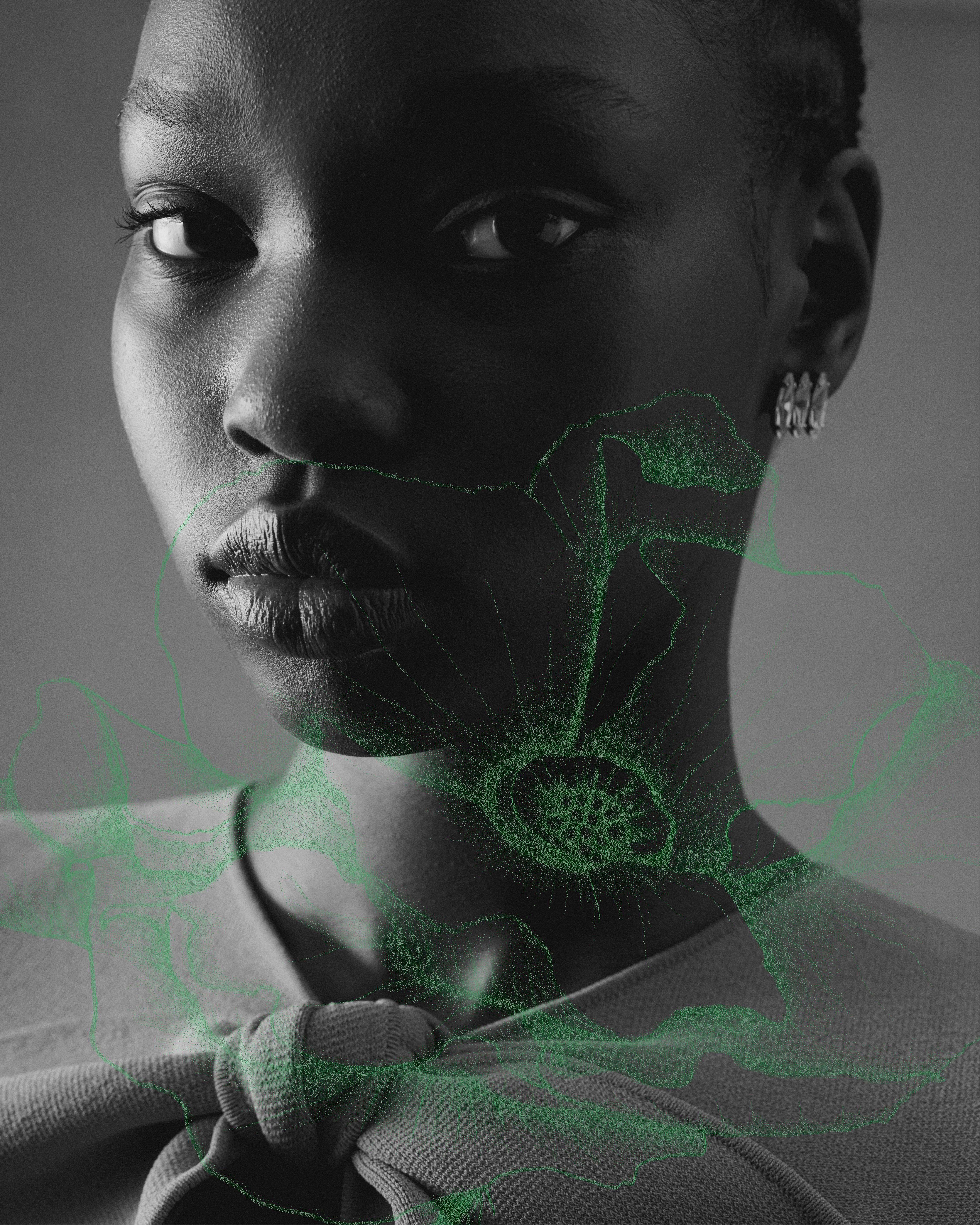 Black and white close up of model's face with green poppy ilustration overlaid on top