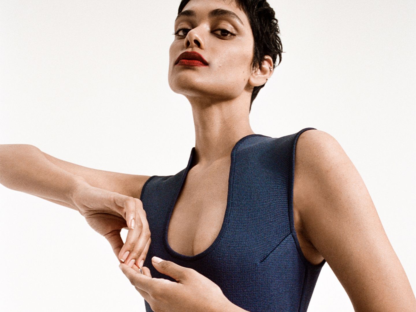 Close up image of Zinnia Kumar from top of head to chest in the Crepe Knit Scoop Neck Dress
