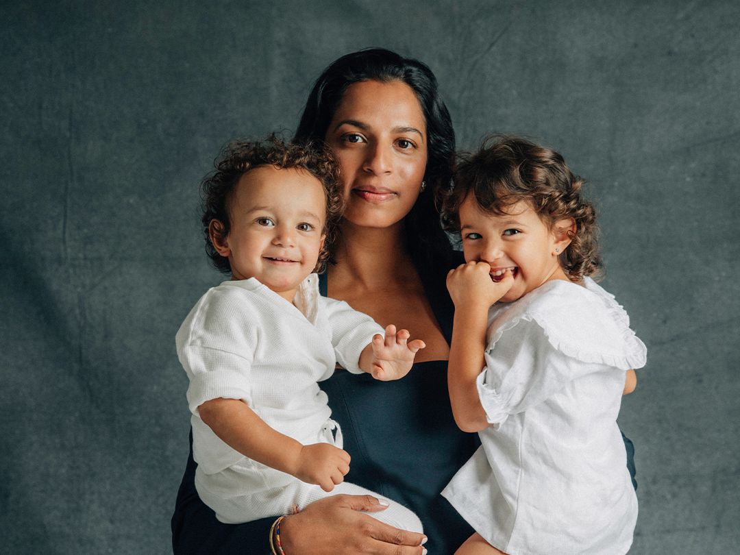 Shamini Rajarethnam standing holding her two toddlers