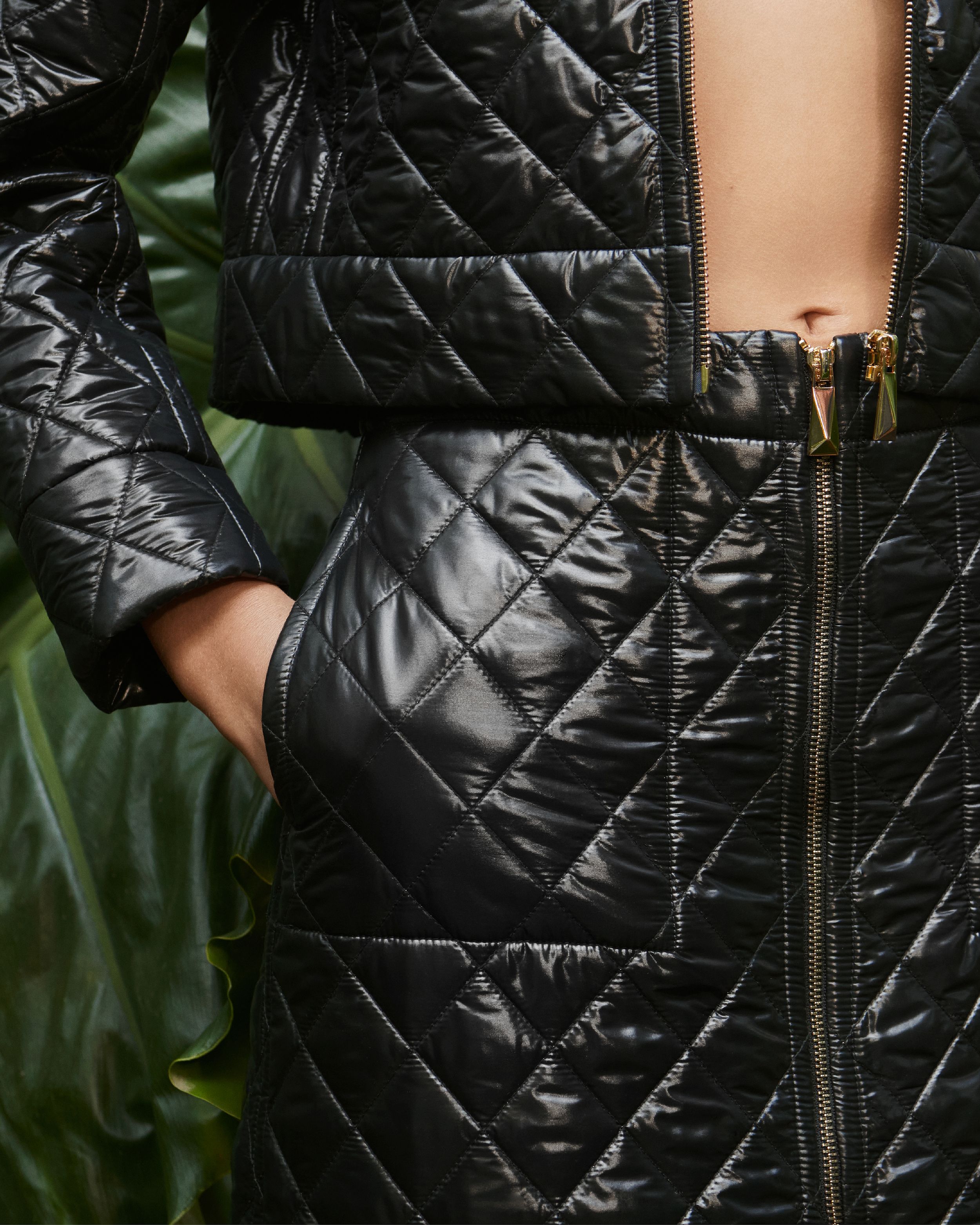 Detail shot of the quilting on a black jacket and skirt set with gold hardware