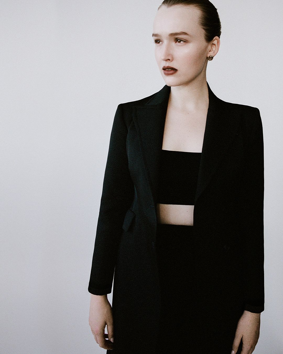 Maddison Brown standing in black jacket and black bandeau top