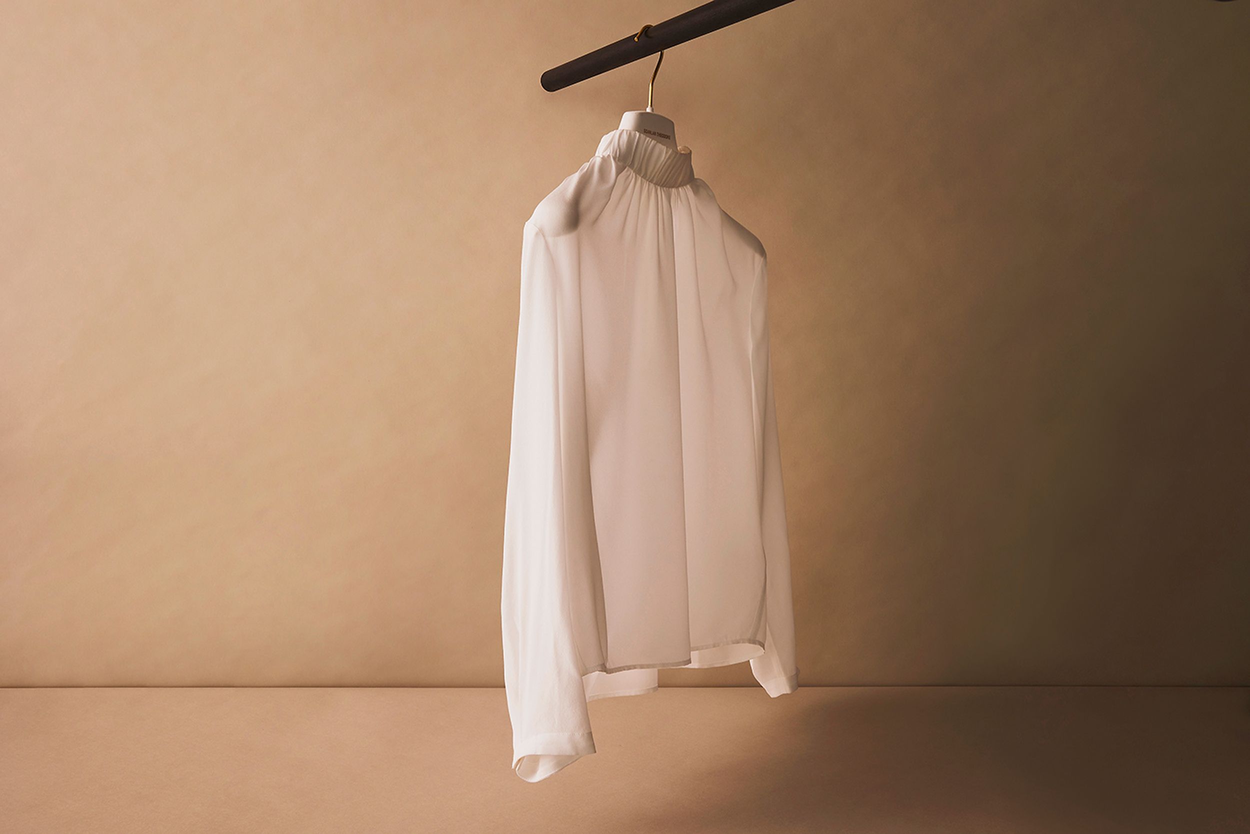 Scanlan Theodore white silk blouse hanging on a rail.