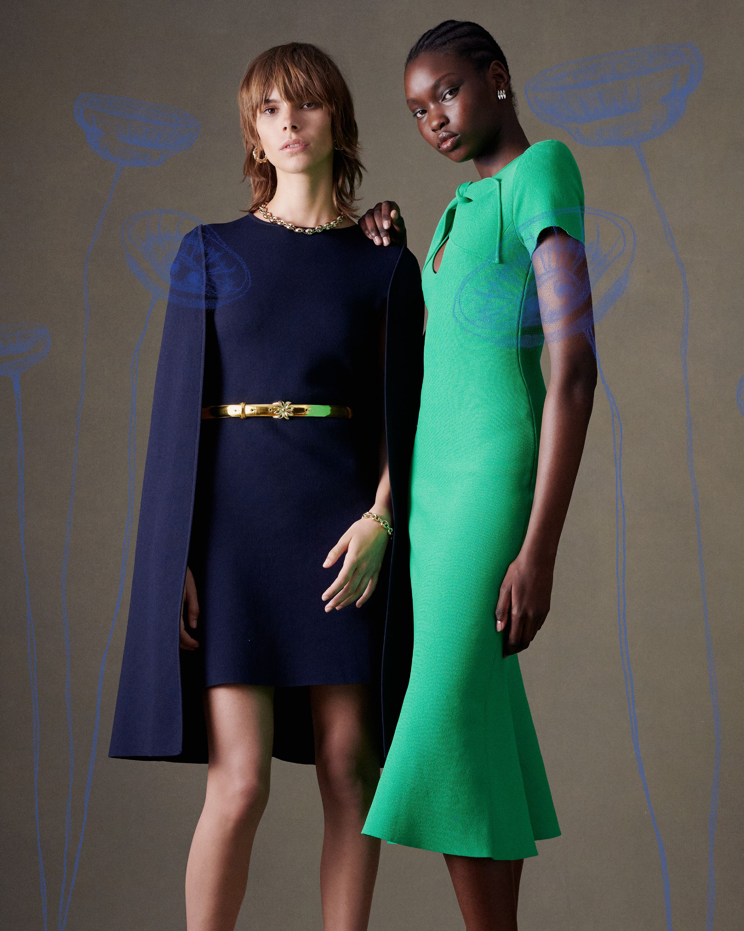 Two models standing together - one wears a navy Crepe Knit cape dress and the other an emerald Crepe Knit dress