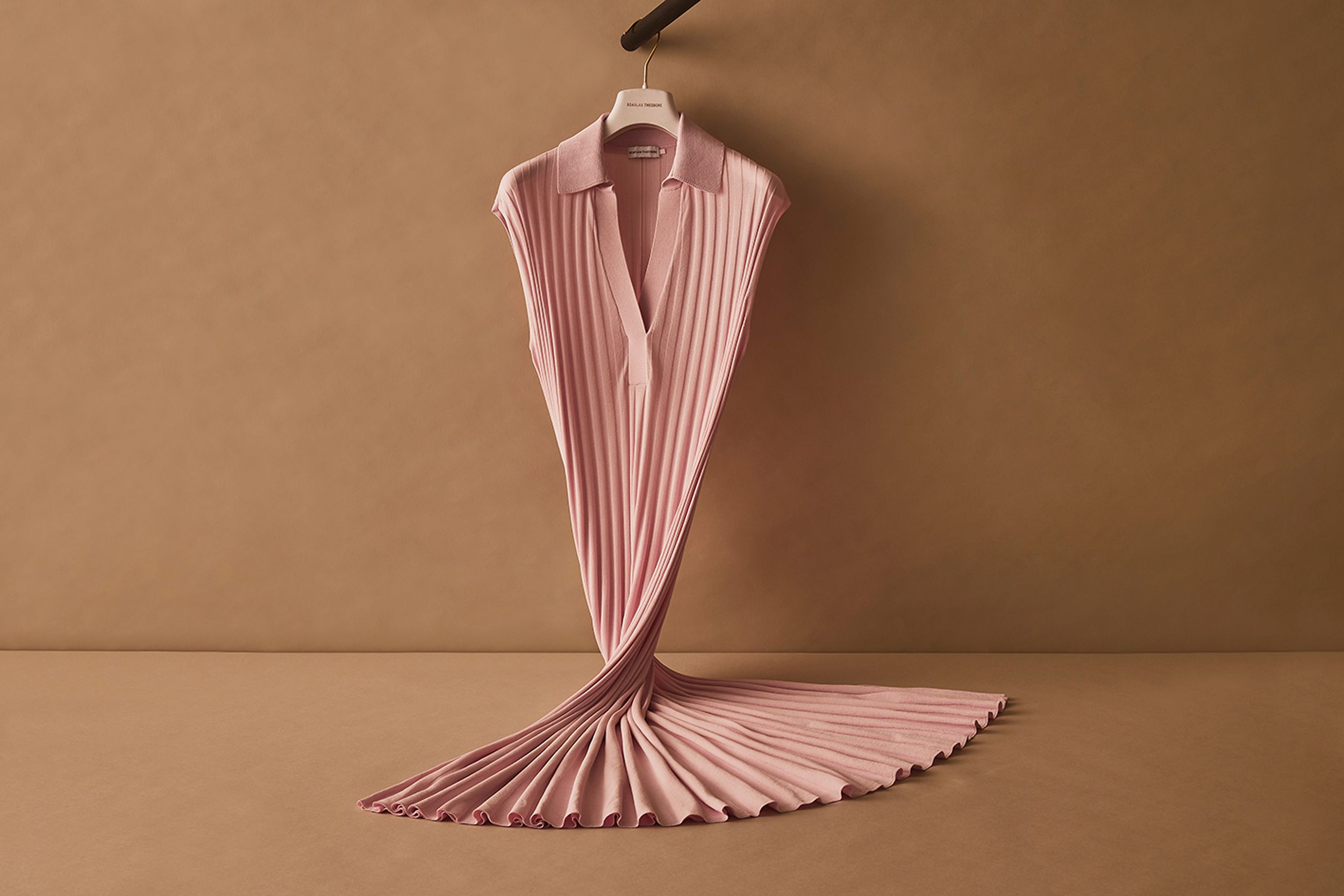 Scanlan Theodore pink pleated rib dress hanging on a rail in a twisted formation.