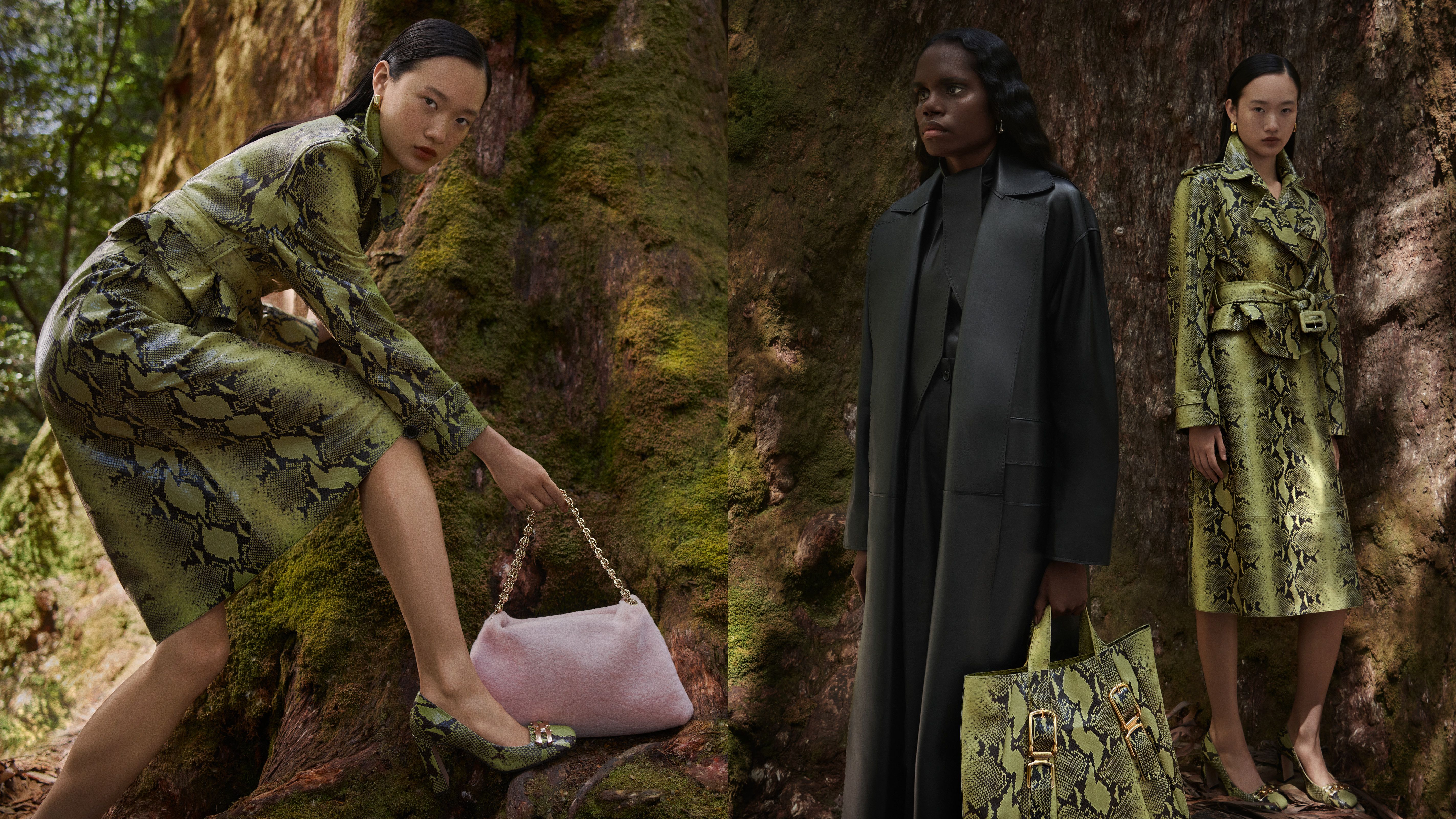 Venus He and Venus He standing in front of a tree wearing a reptile-print leather trench coatstanding in front of a tree wearing a reptile-print leather trench coat and black leather trench, respectively.