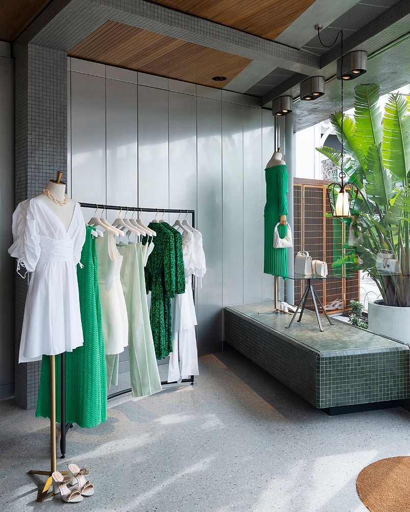 Store window display with bright green and white dresses