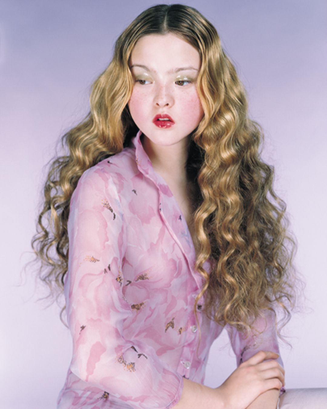 Devon Aoki posing with arms loosely crossed wearing a pink floral collared shirt