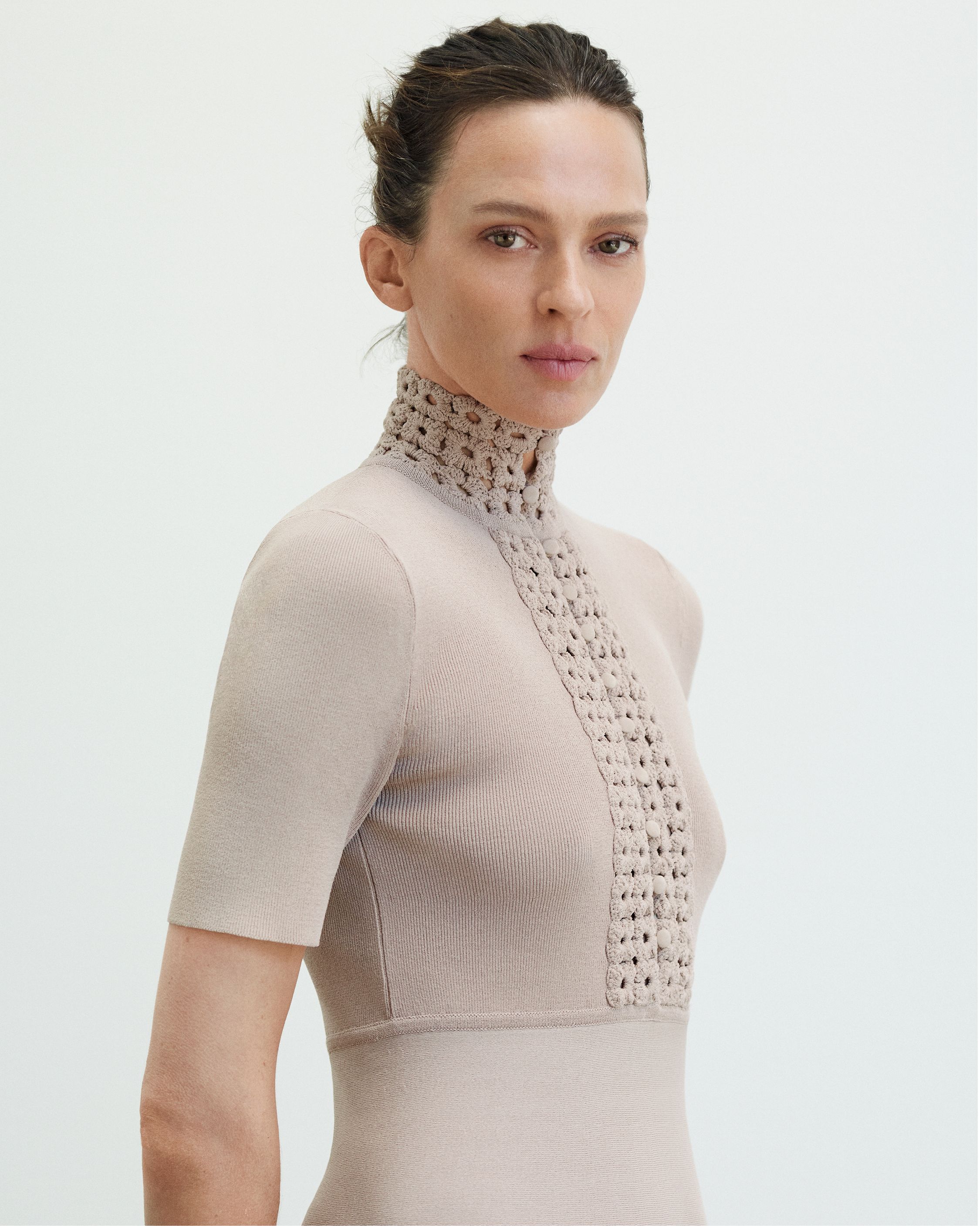 Élise Crombez close up shot gazing at the camera wearing a Crepe Knit neutral-toned dress