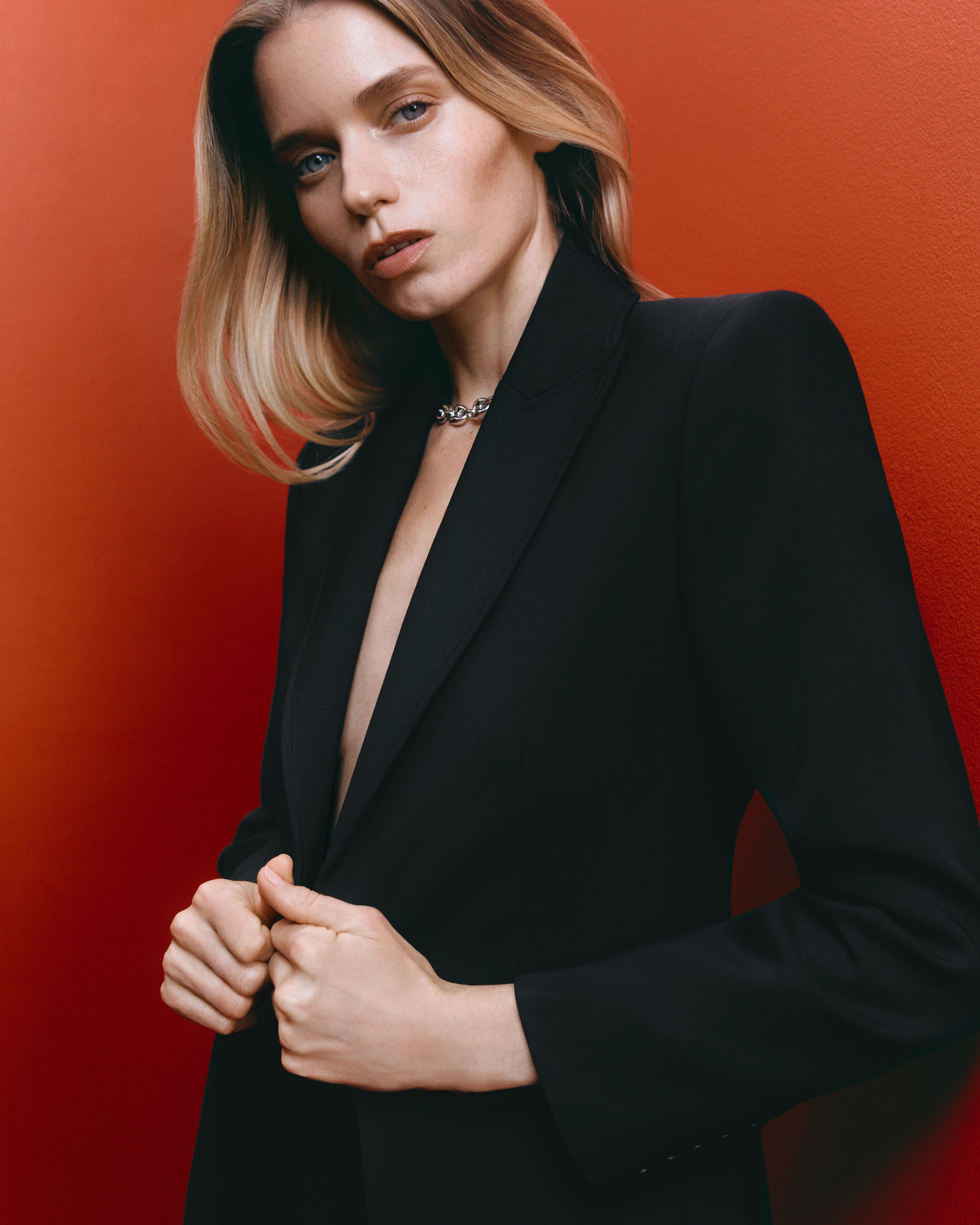 Abbey Lee wearing a black suit jacket with hands on the lapels