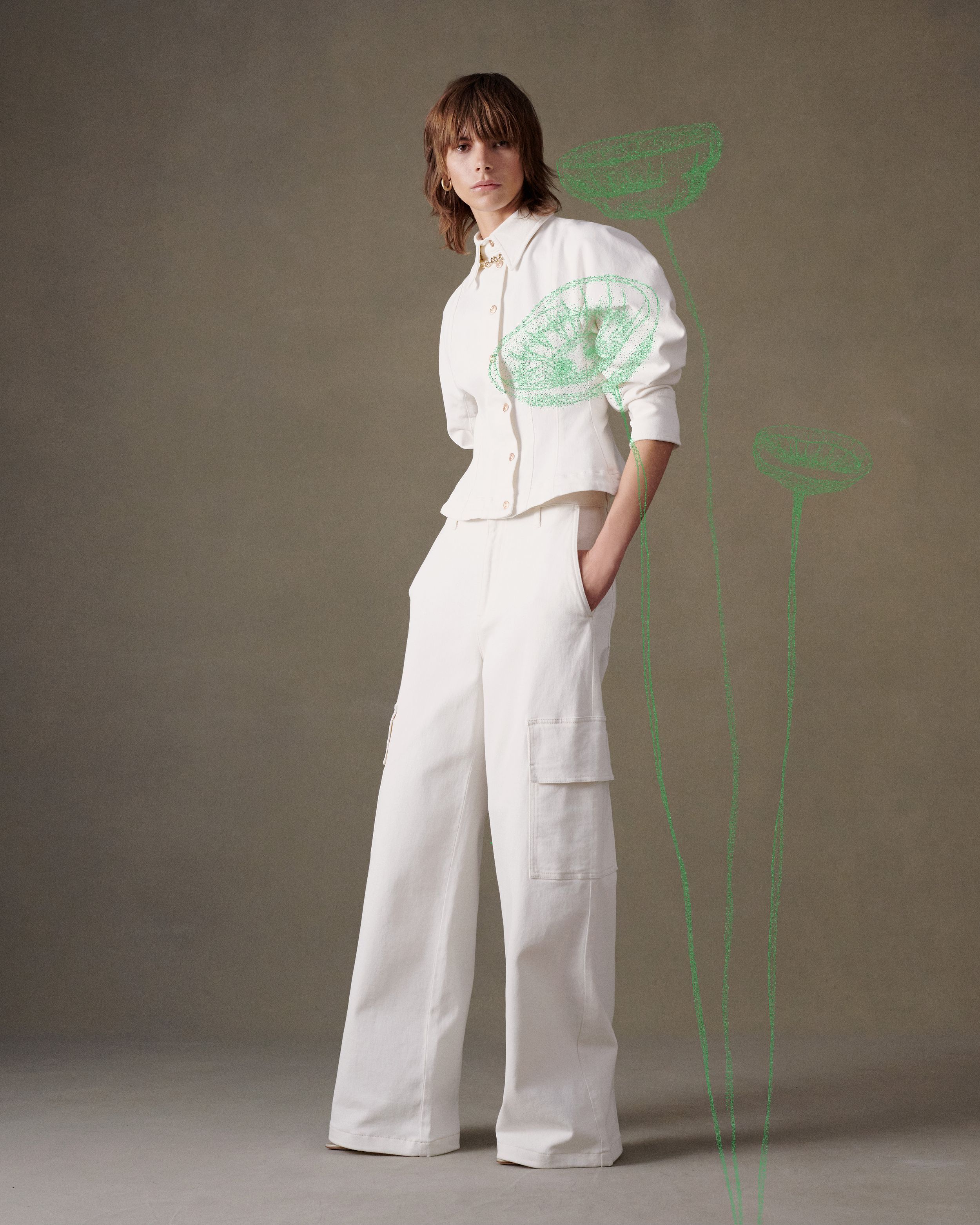 Model standing in white double denim set with a green poppy illustration overlaid on top