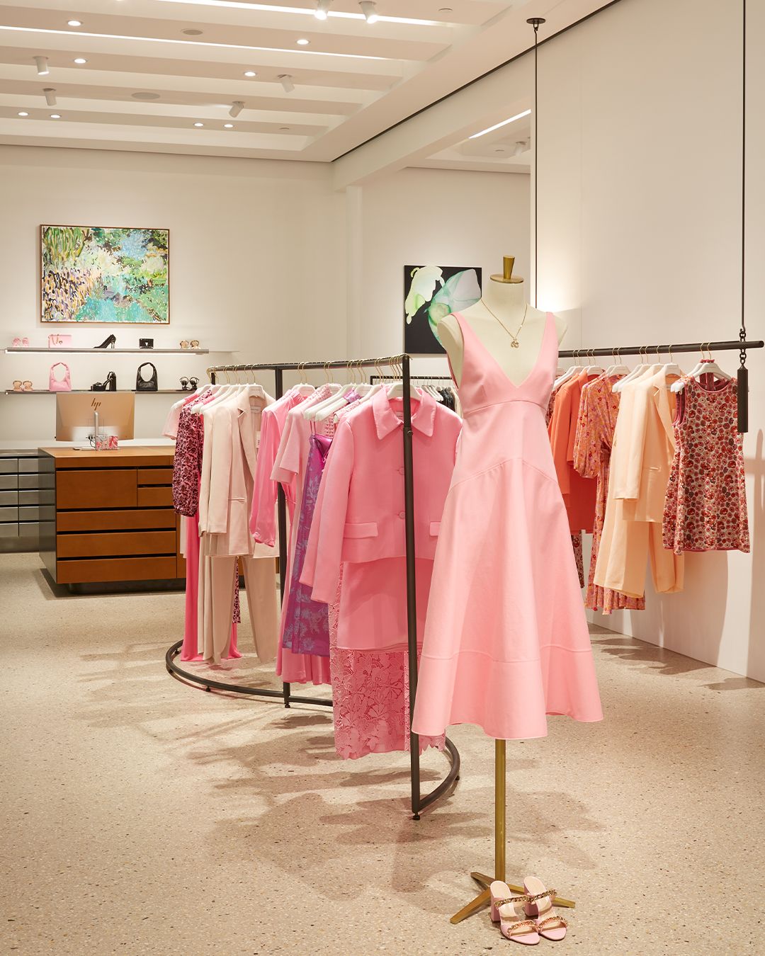 Interior of women's fashion boutique with clothing ranks feautirng pink and orange clothing
