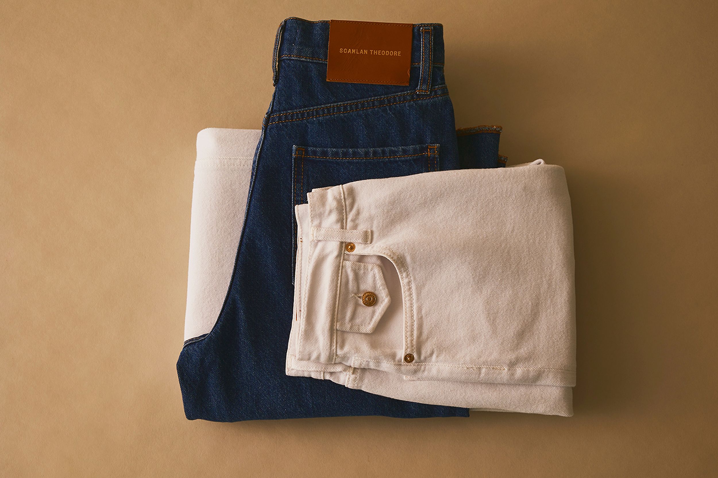 Scanlan Theodore denim jeans folded and stacked on top of each other in range of colours.