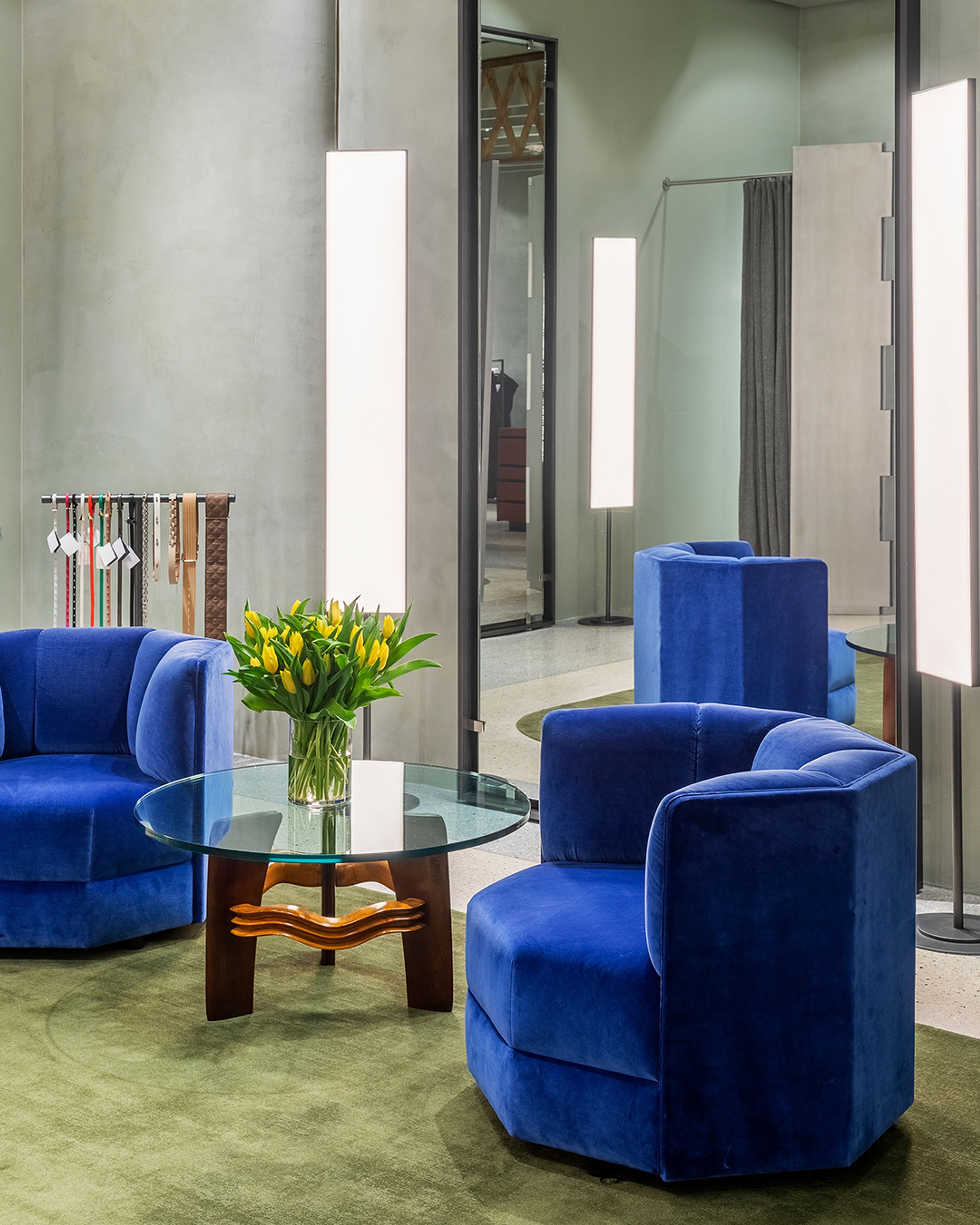 Interior of woman's fashion boutique with two blue velvet seats on a green carpet