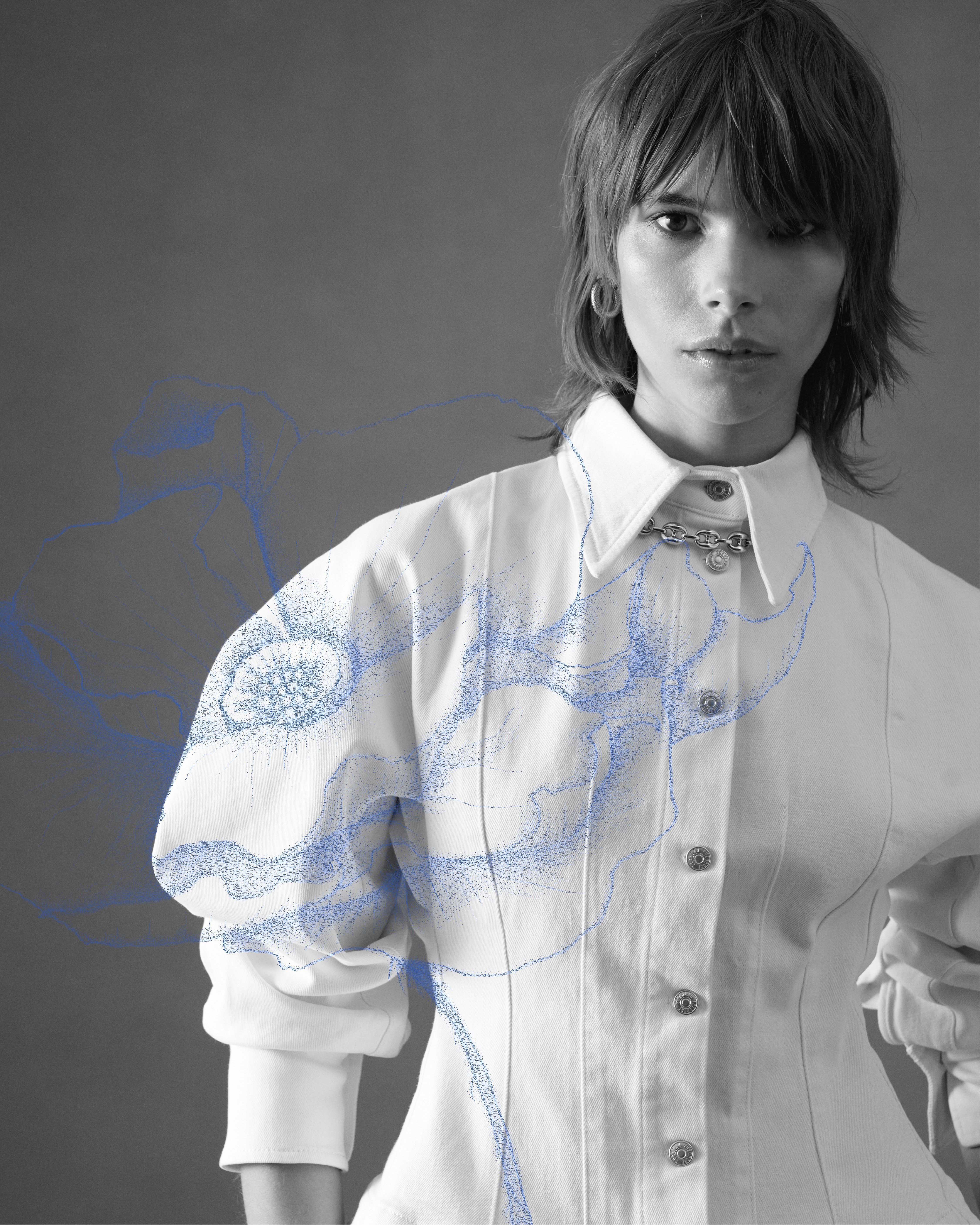 Black and white image of model wearing a white denim jacket with blue poppy illustration overlaid on top