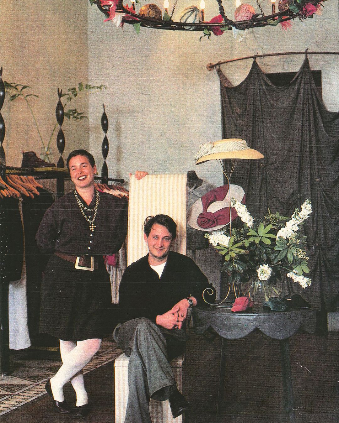 Co-founders Fiona Scanlan and Gary Theodore in their first boutique surrounded by clothing and display of flowers and hats