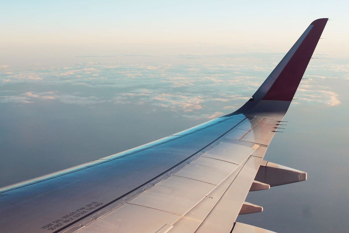 An airplane wing over clouds during flight