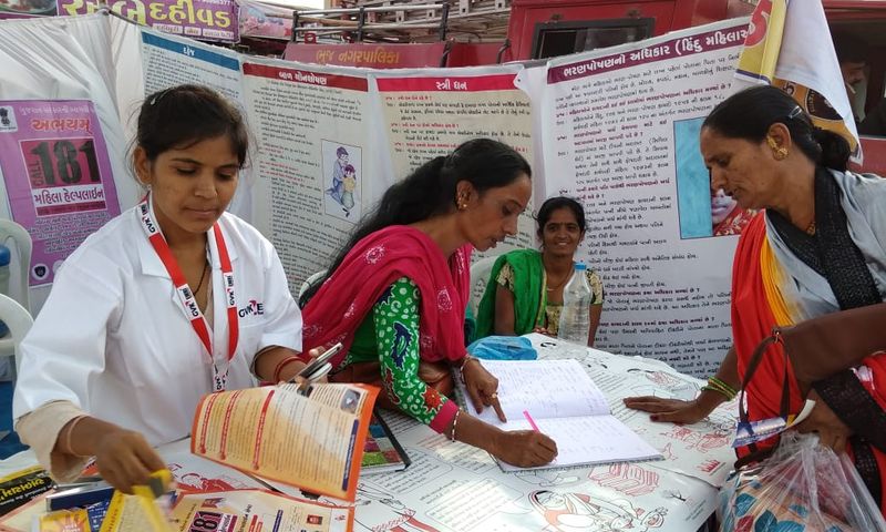A member of the public and a medical professional interact at a stall.