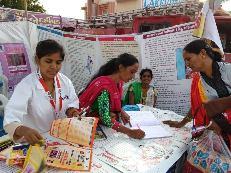 3 women discuss the contents of a book placed on the table in the middle