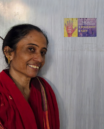 An over the shoulder image of someone holding a leaflet for a helpline for women.