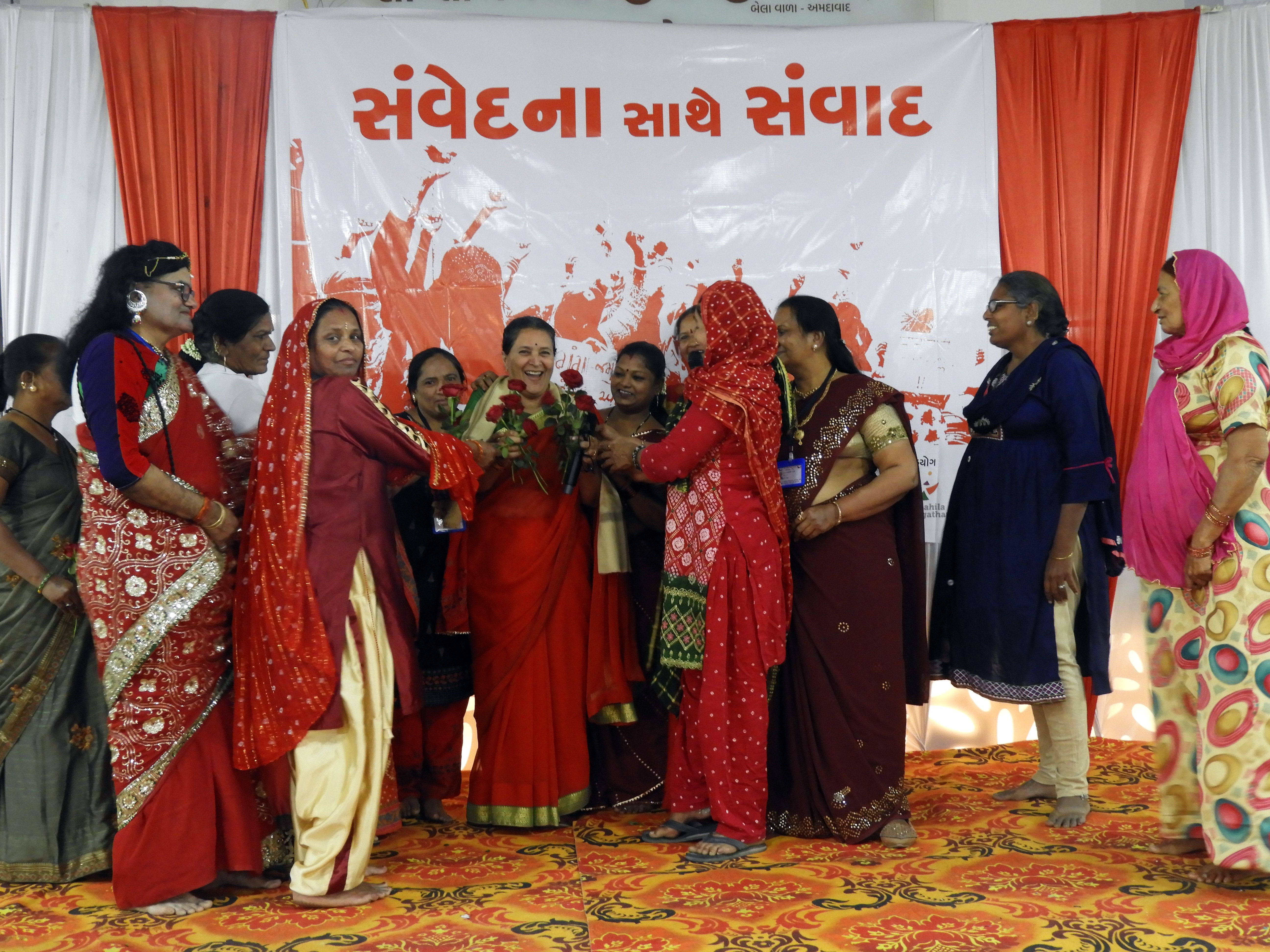 A group of women honour / present an award to a woman on stage