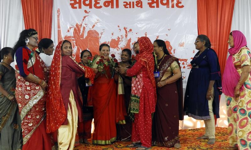 A group of women honour / present an award to a woman on stage
