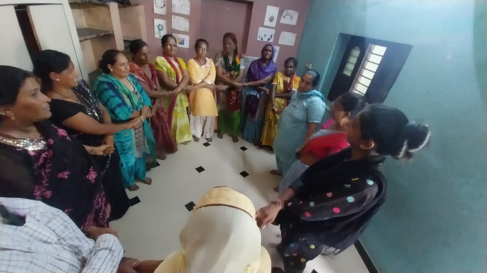 A group of women standing indoors in a circle